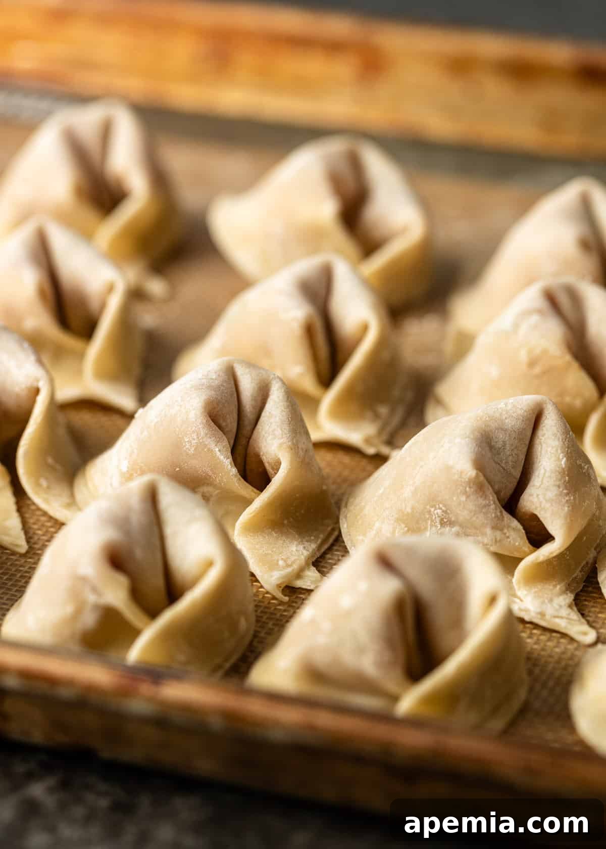 closeup: wontons on a baking sheet ready for my wonton soup recipe