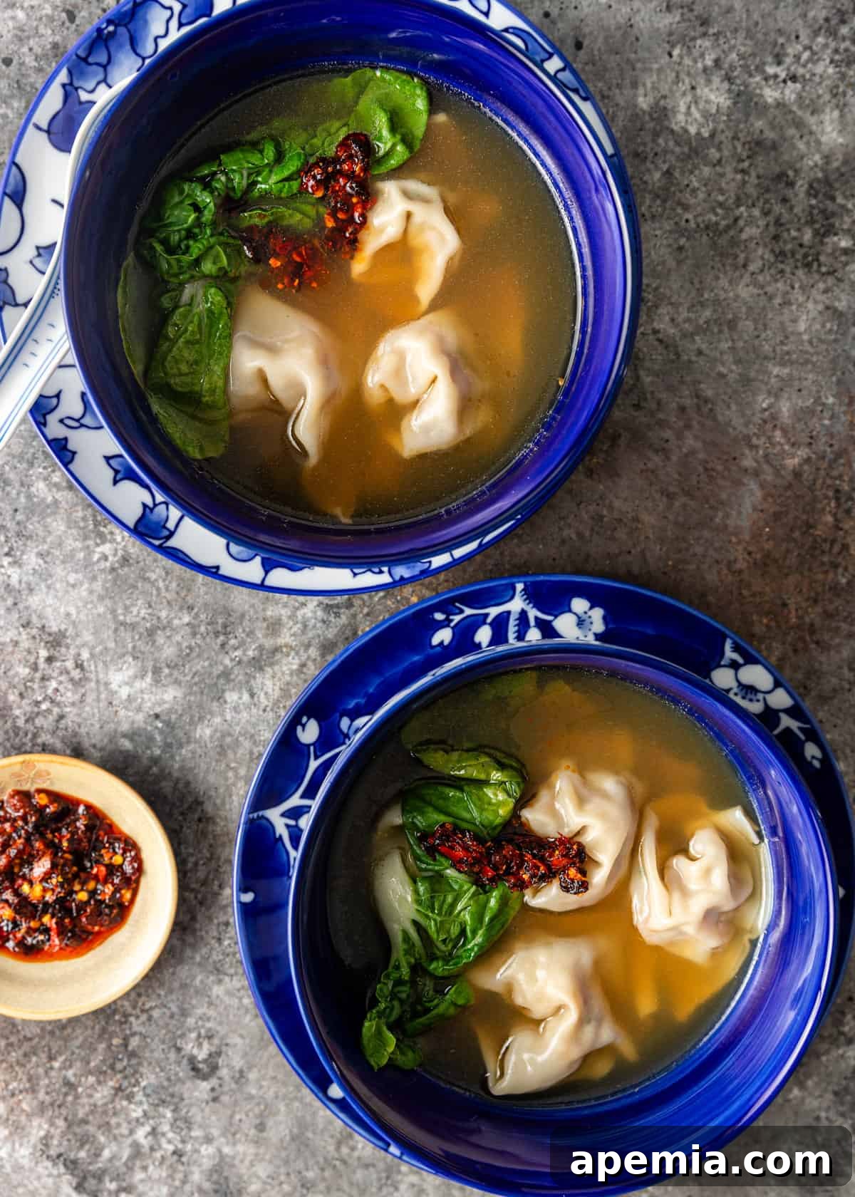 overhead: two bowls of wonton soup on a counter