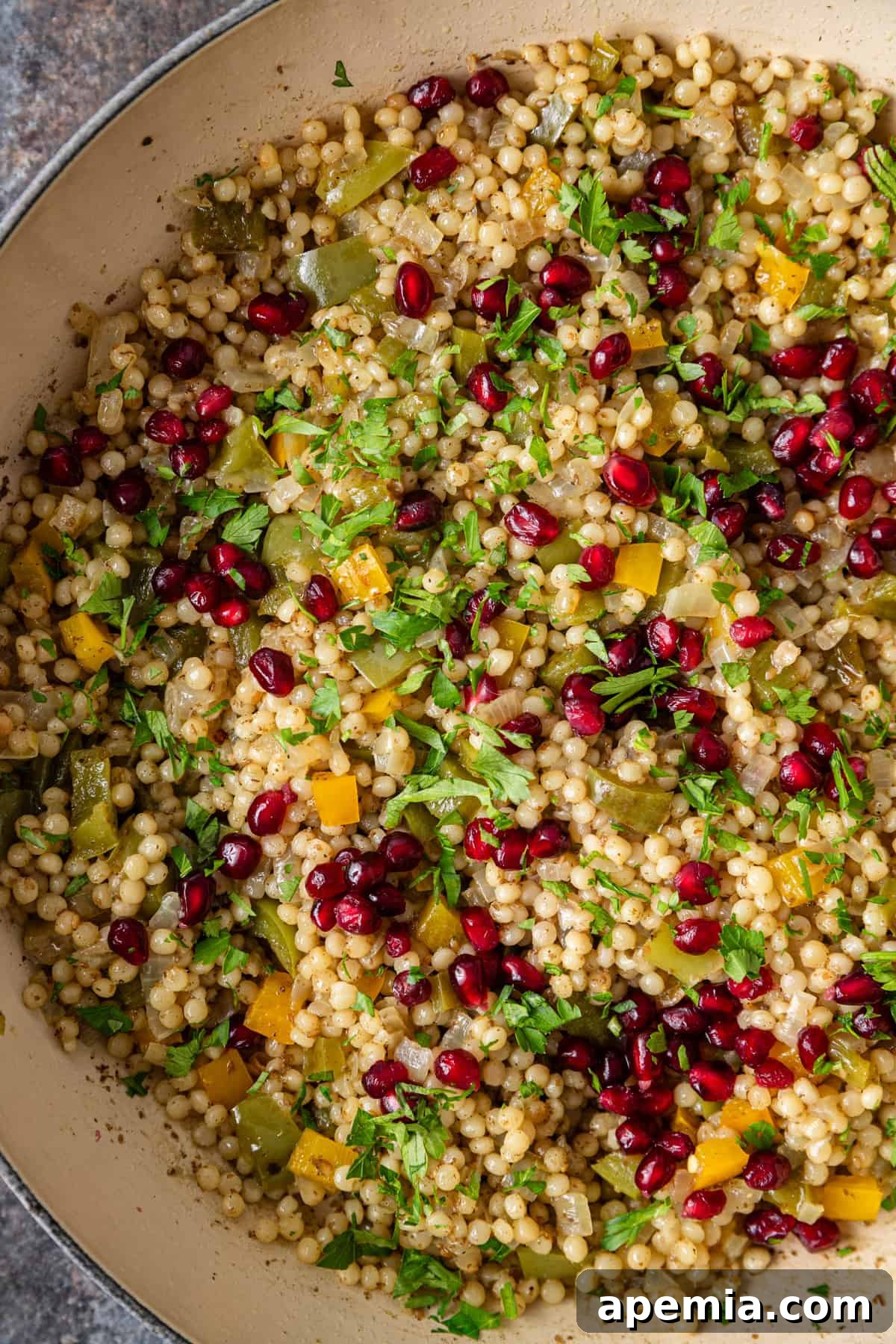 Aromatic Za'atar Couscous and Vibrant Market Vegetables 7 A detailed overhead shot of Za'atar Pearl Couscous simmering in a skillet, showing the perfectly cooked pearls and colorful vegetables.