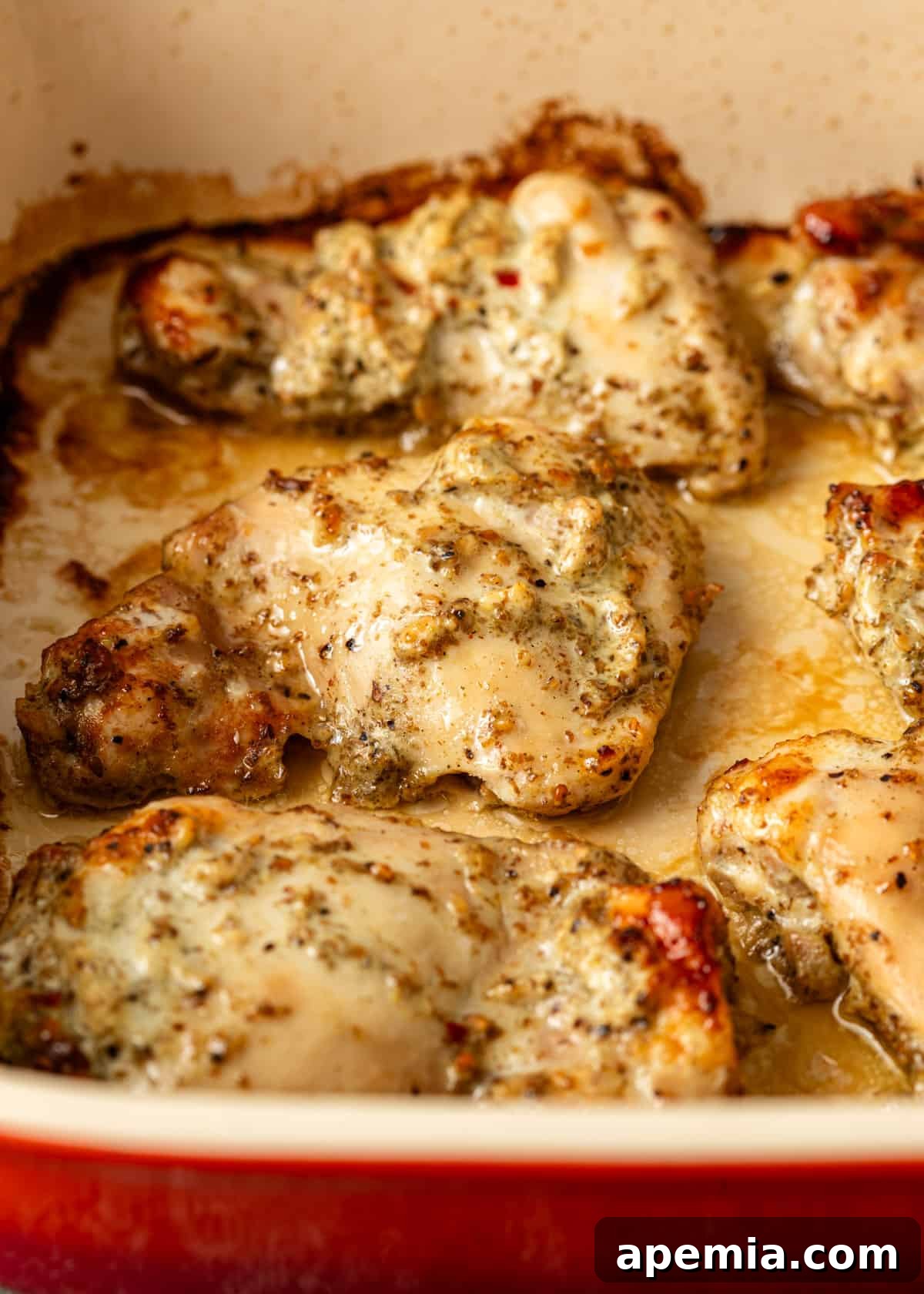Close-up of perfectly baked za'atar yogurt chicken nestled in a pan, glistening with its savory sauce.