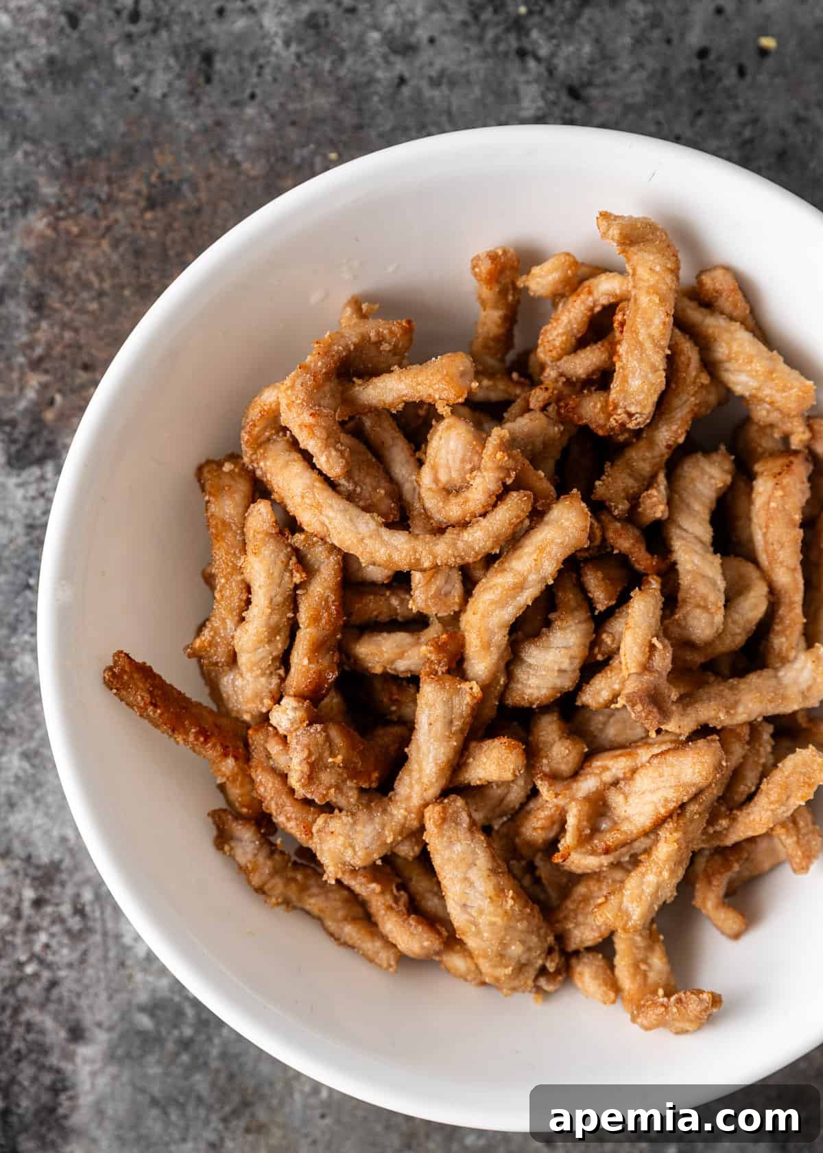 overhead: fried pork in a bowl for vinegar pork stir fry