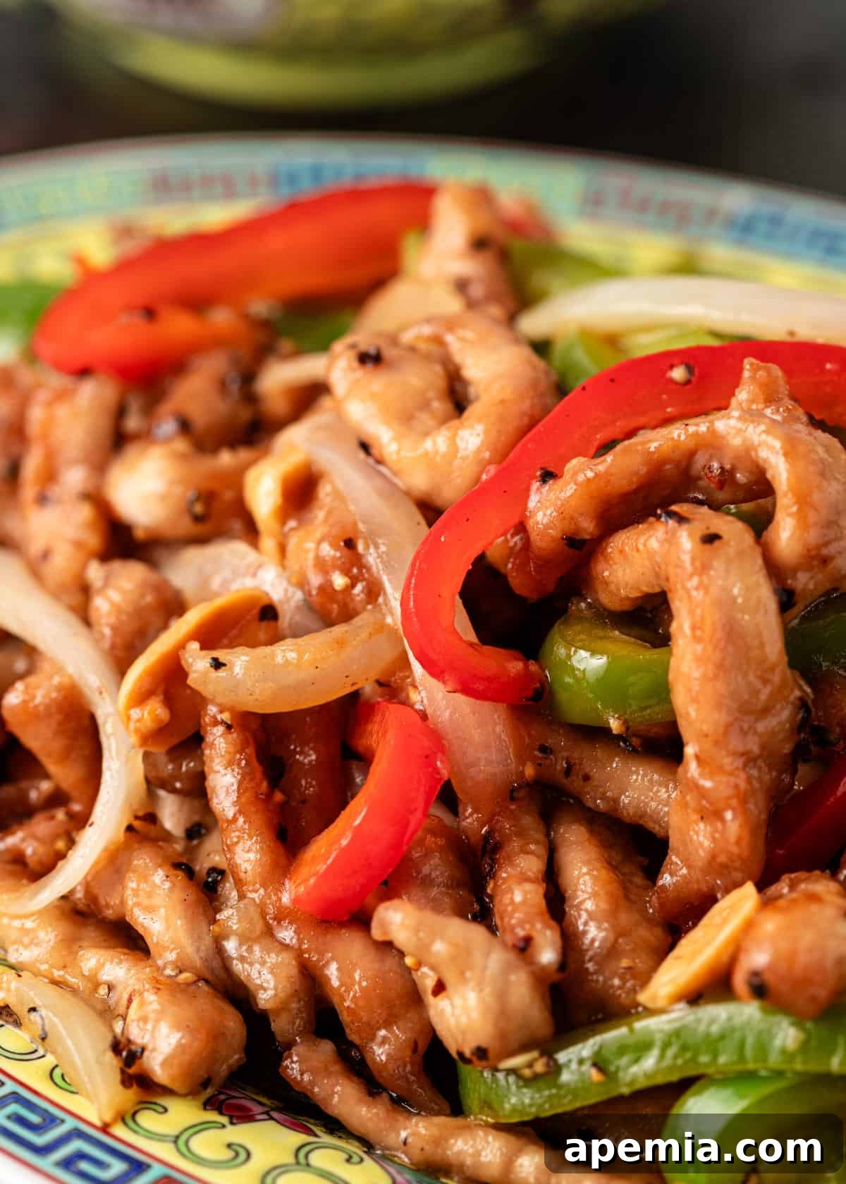 extreme closeup: black pepper and vinegar pork stir fry with bell peppers and onions
