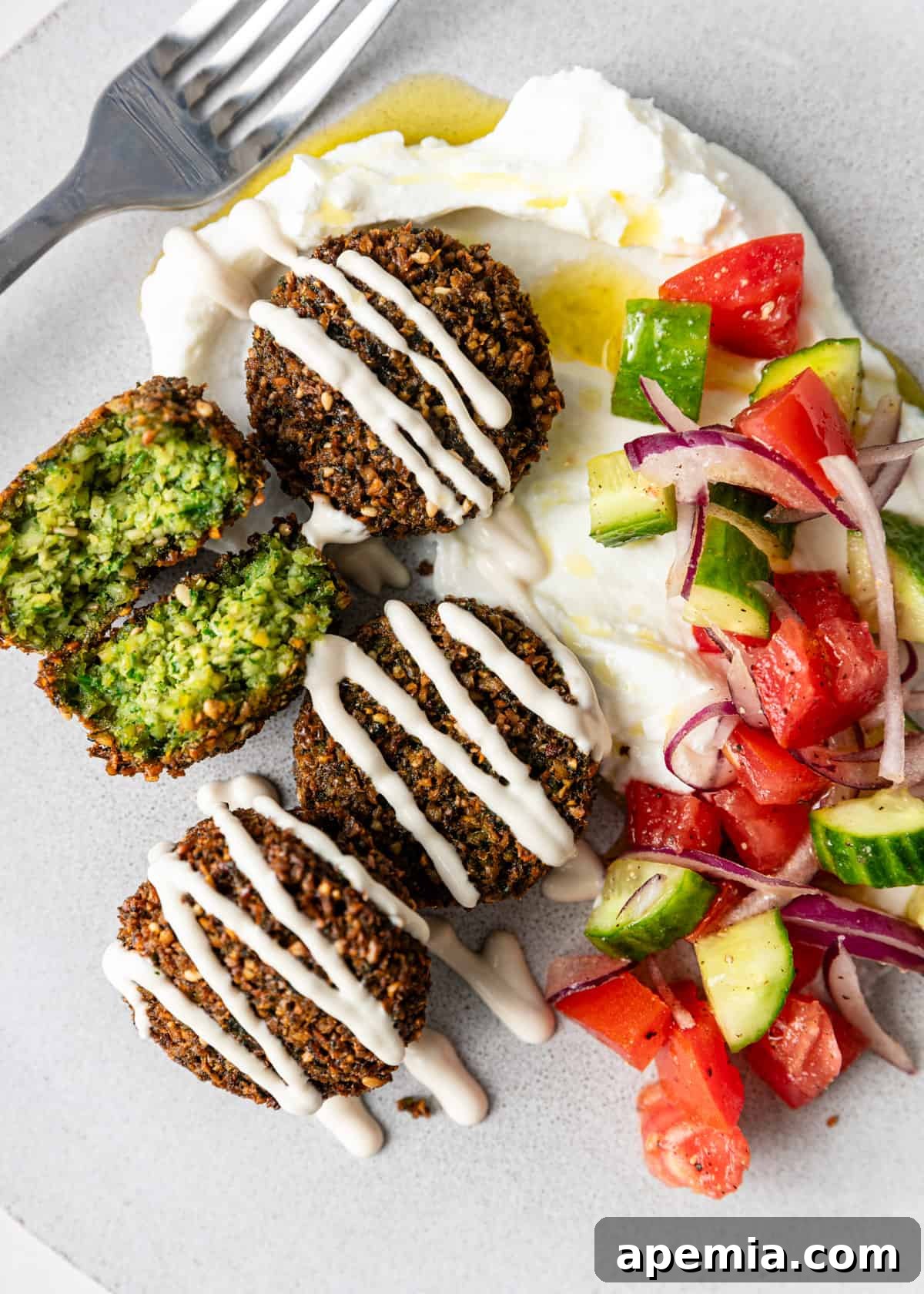 overhead: my falafel recipe over creamy yogurt sauce and chopped veggies