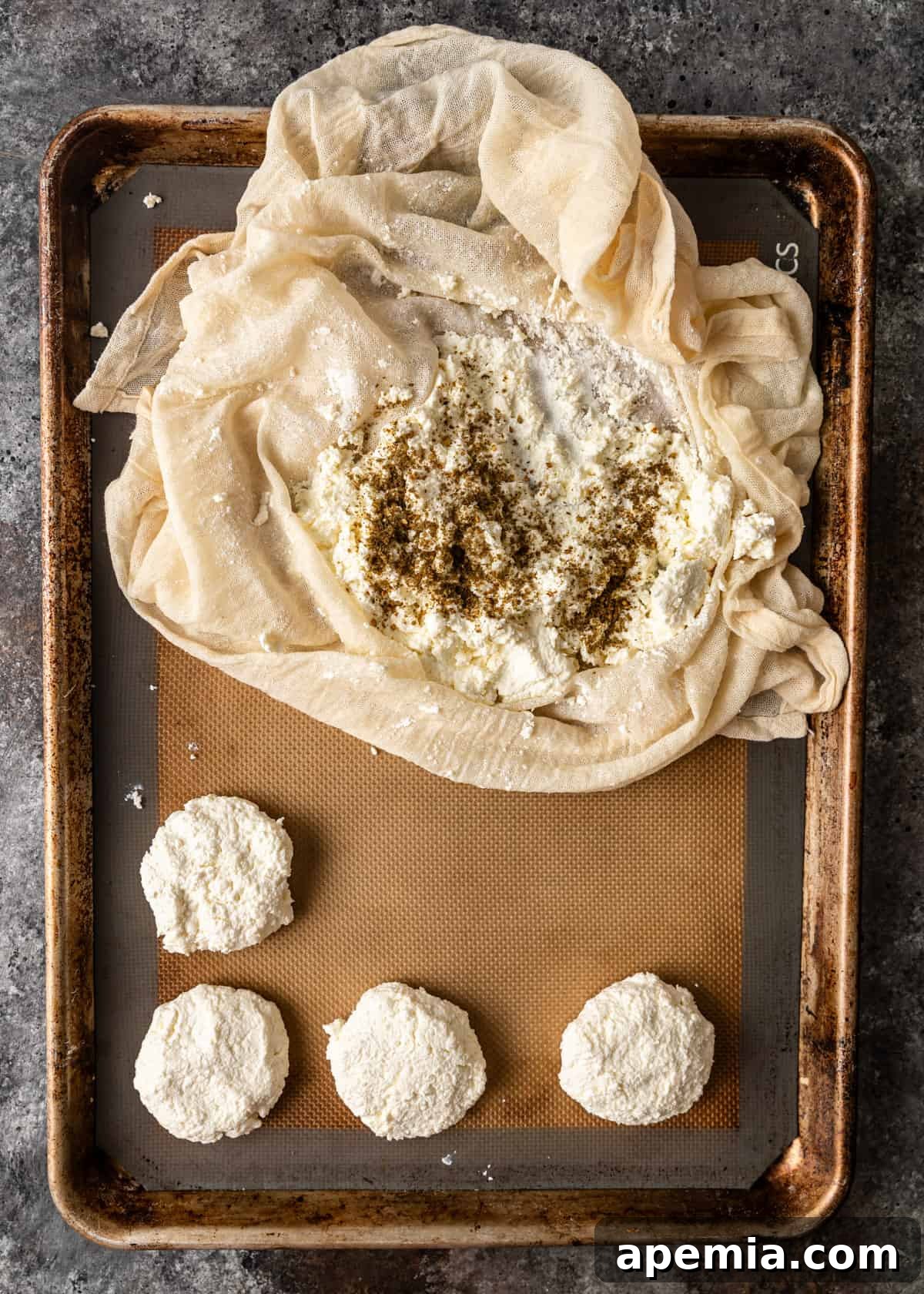 Overhead process shot: Forming the Jibin cheese balls on a baking sheet, showing the soft curds being shaped by hand.