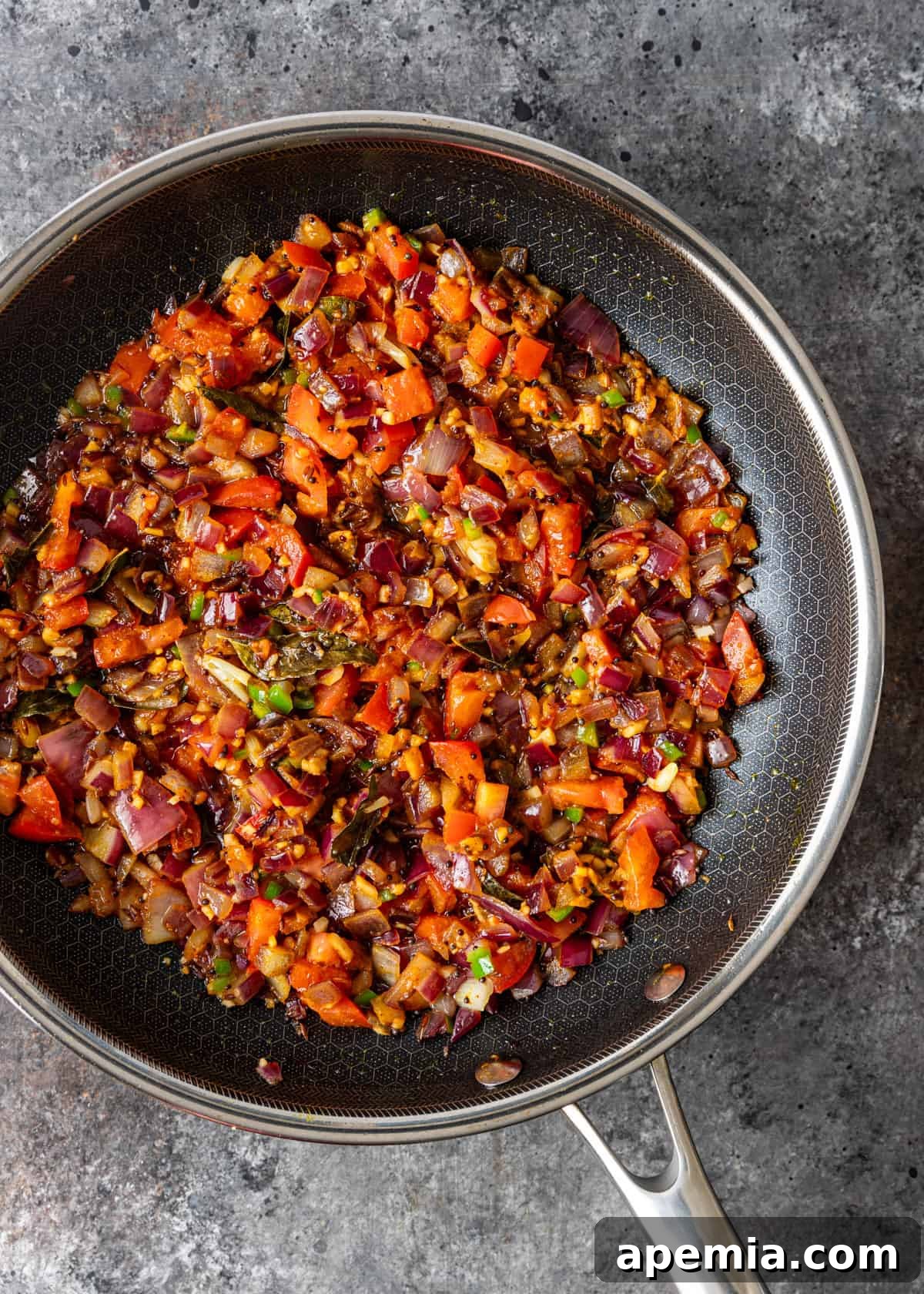 overhead process shot: sautéed ingredients and added spices in a skillet