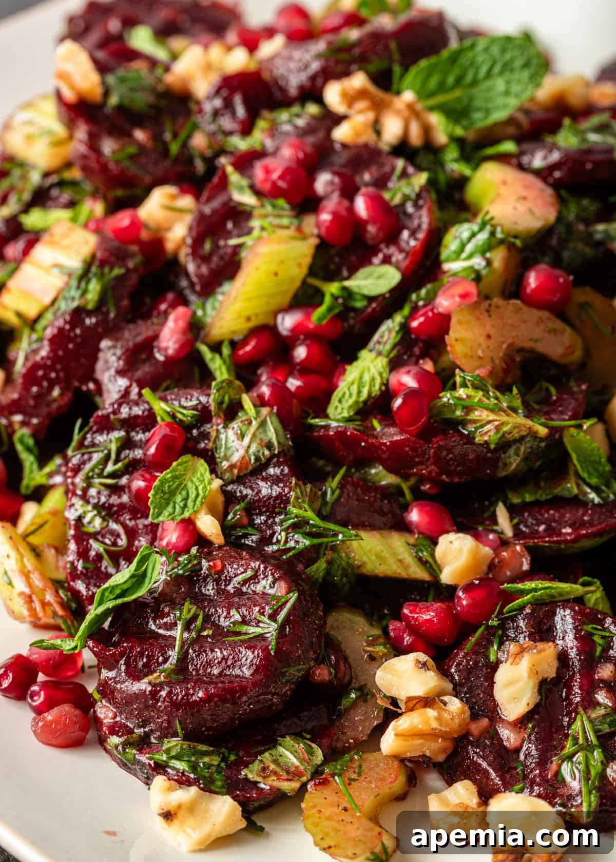 Vibrant Turkish Beet Salad 3 closeup: my Turkish beet salad recipe featuring finely chopped fresh herbs, walnuts, and glistening pomegranate seeds
