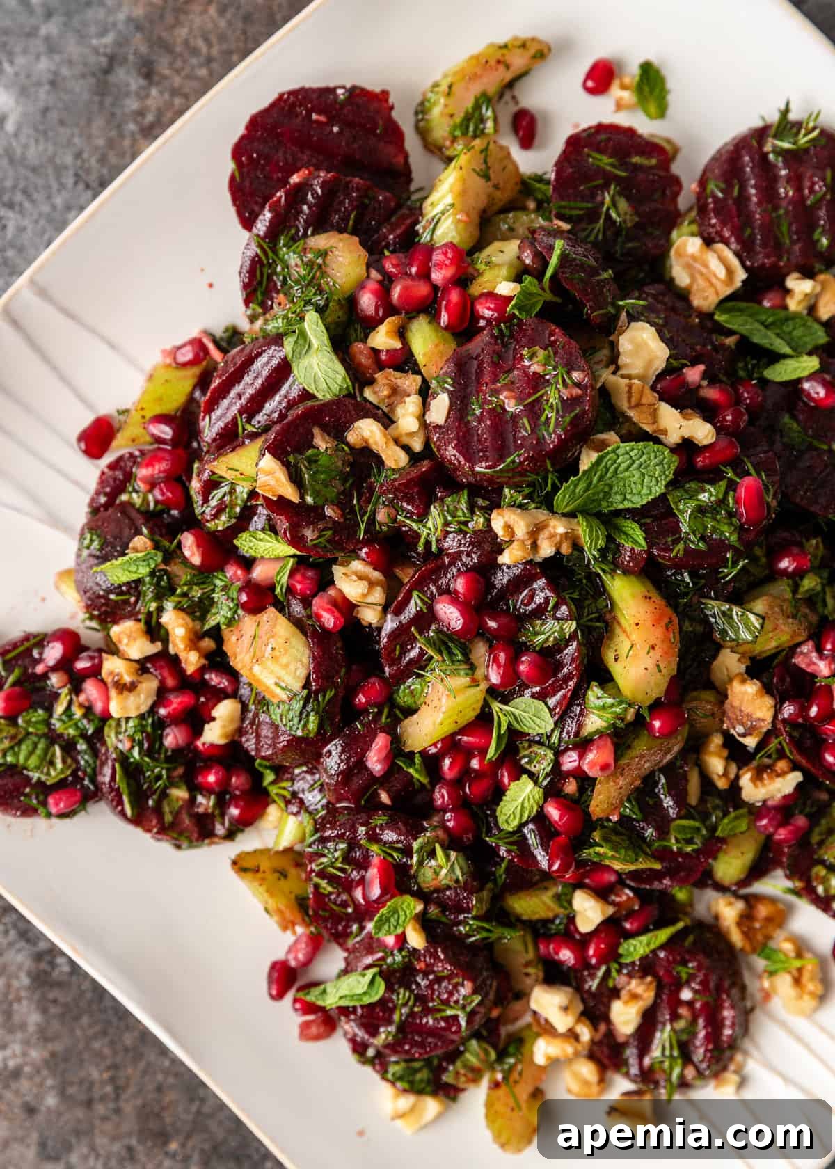 Vibrant Turkish Beet Salad 7 overhead closeup: a serving of Turkish beet salad beautifully presented on a pristine white plate, garnished with fresh herbs