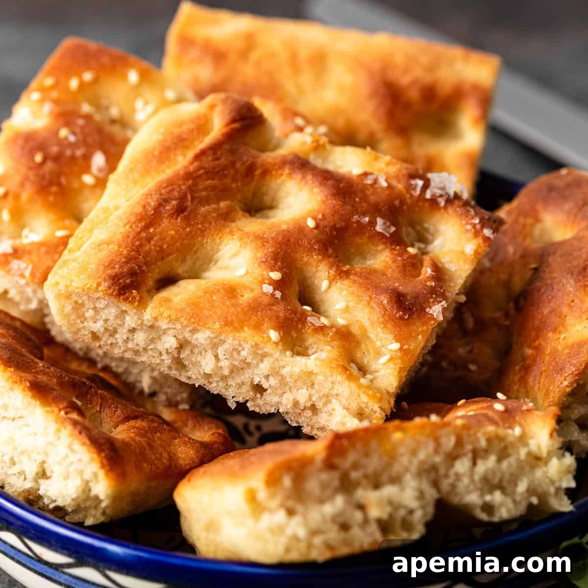 closeup: several slices of golden brown focaccia bread with flaky sea salt