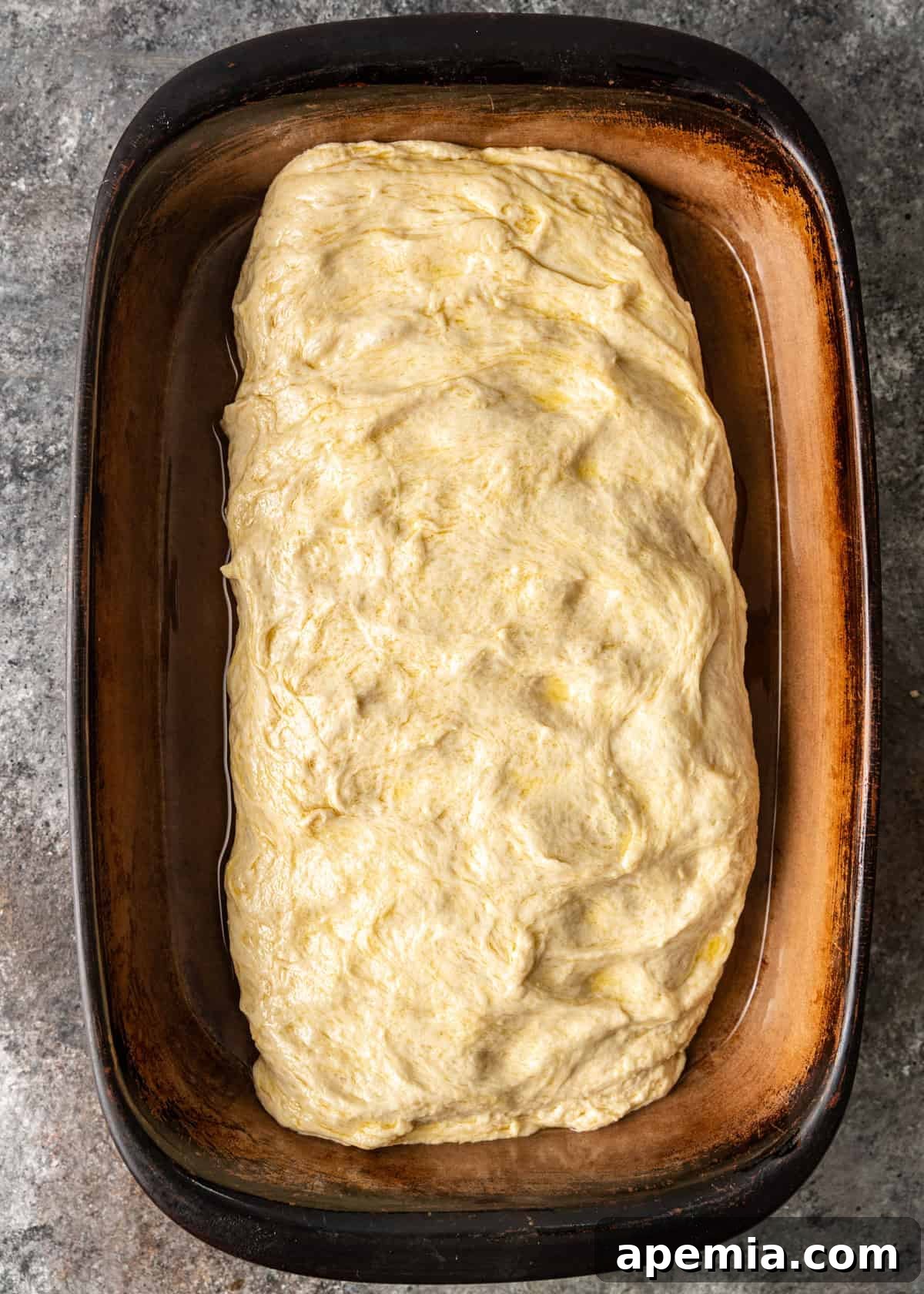 overhead process shot: prepped dough added to 13x9 pan oiled