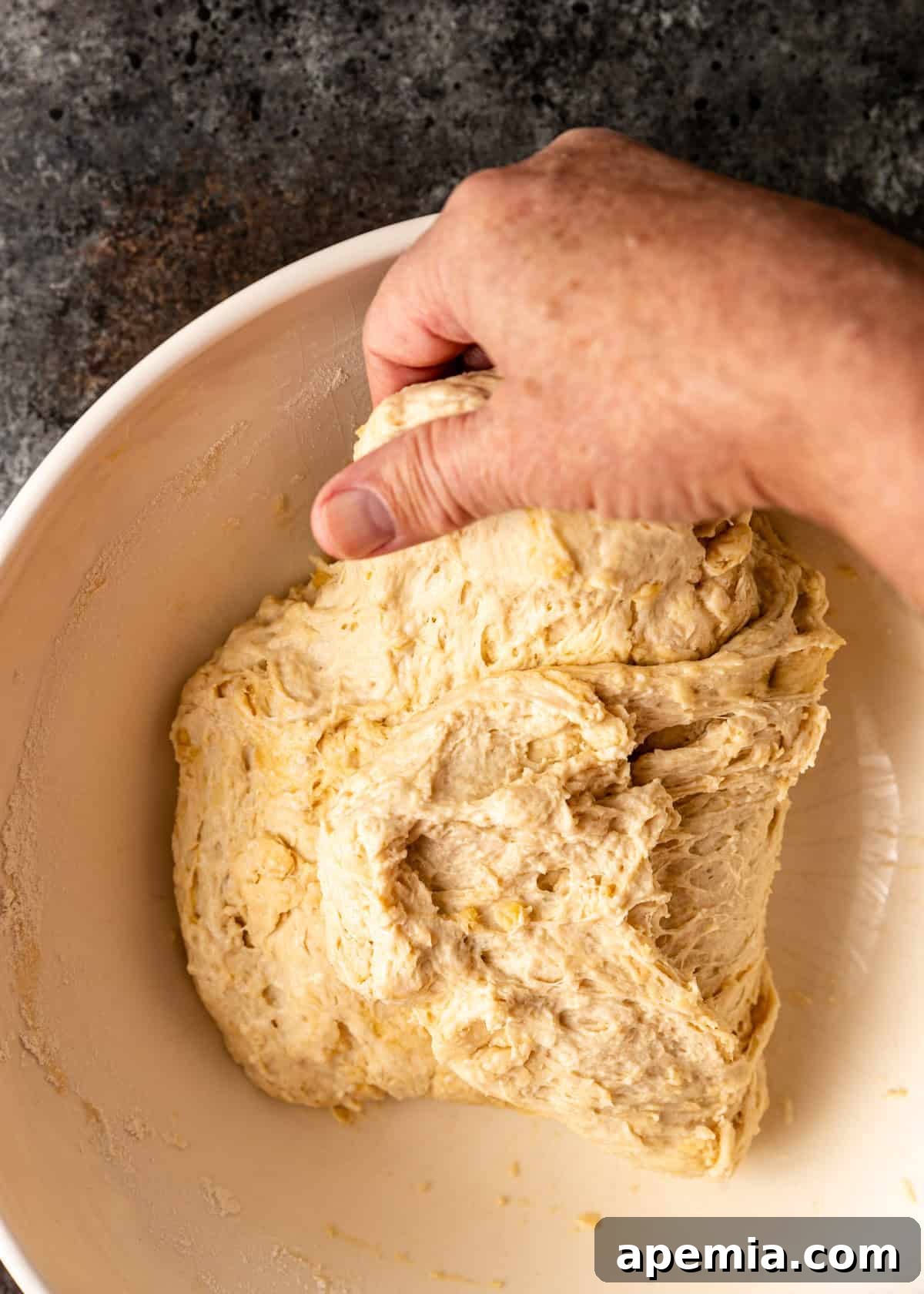overhead process shot: pulling the dough up and over top a second time