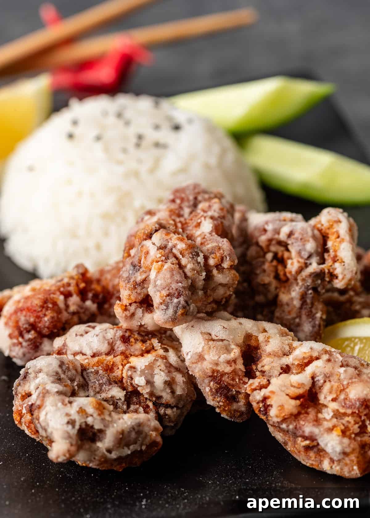 extreme closeup: Japanese fried chicken on a plate with rice and lemon