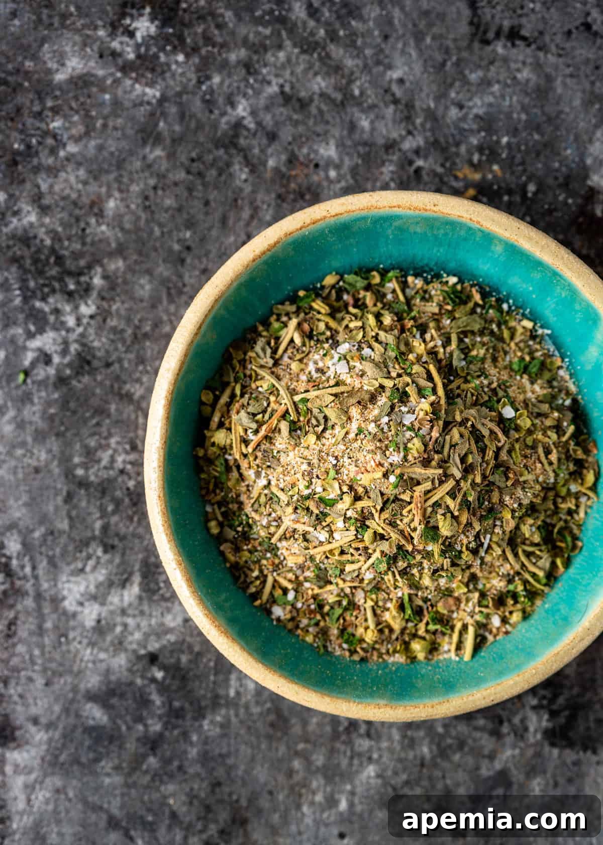 A beautiful, close-up view of a bowl generously filled with my homemade Greek seasoning recipe, highlighting its rich texture and color.
