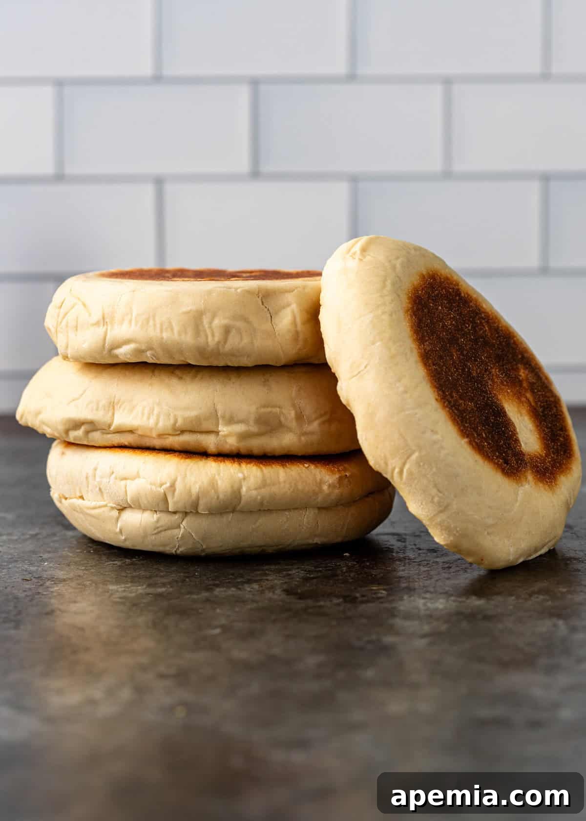Side view of a generous stack of freshly cooked Turkish bazlama flatbreads, arranged on a kitchen countertop, highlighting their inviting, thick and soft texture.