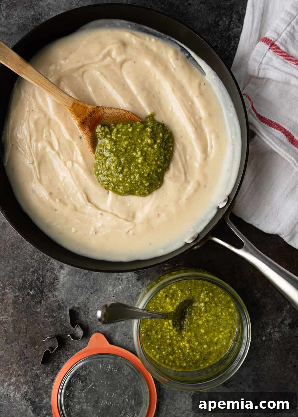 scoop of pesto in alfredo sauce