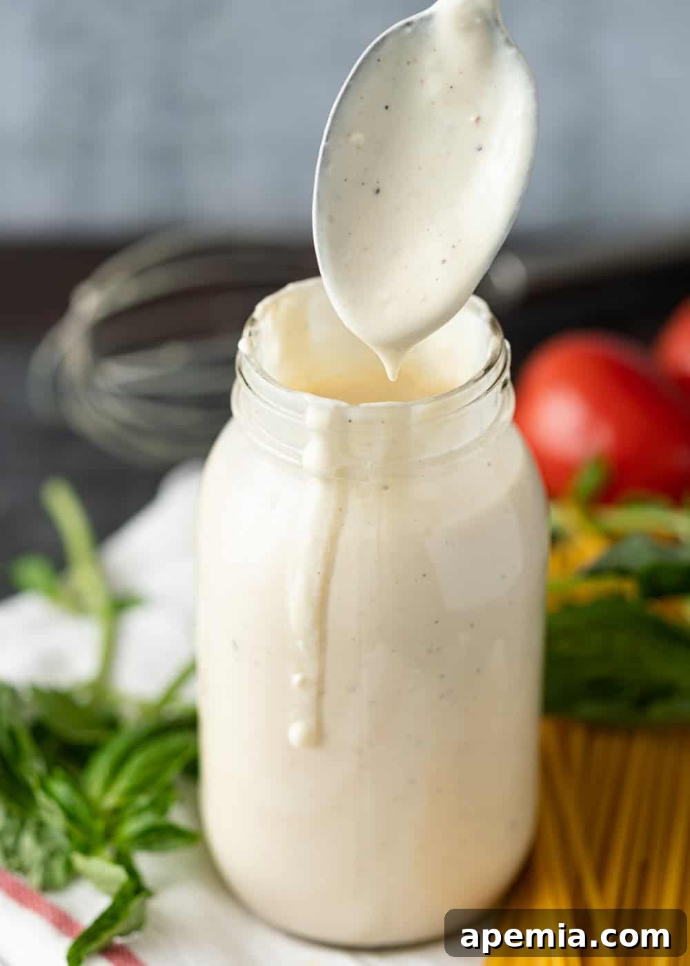 spoon of alfredo sauce with jar