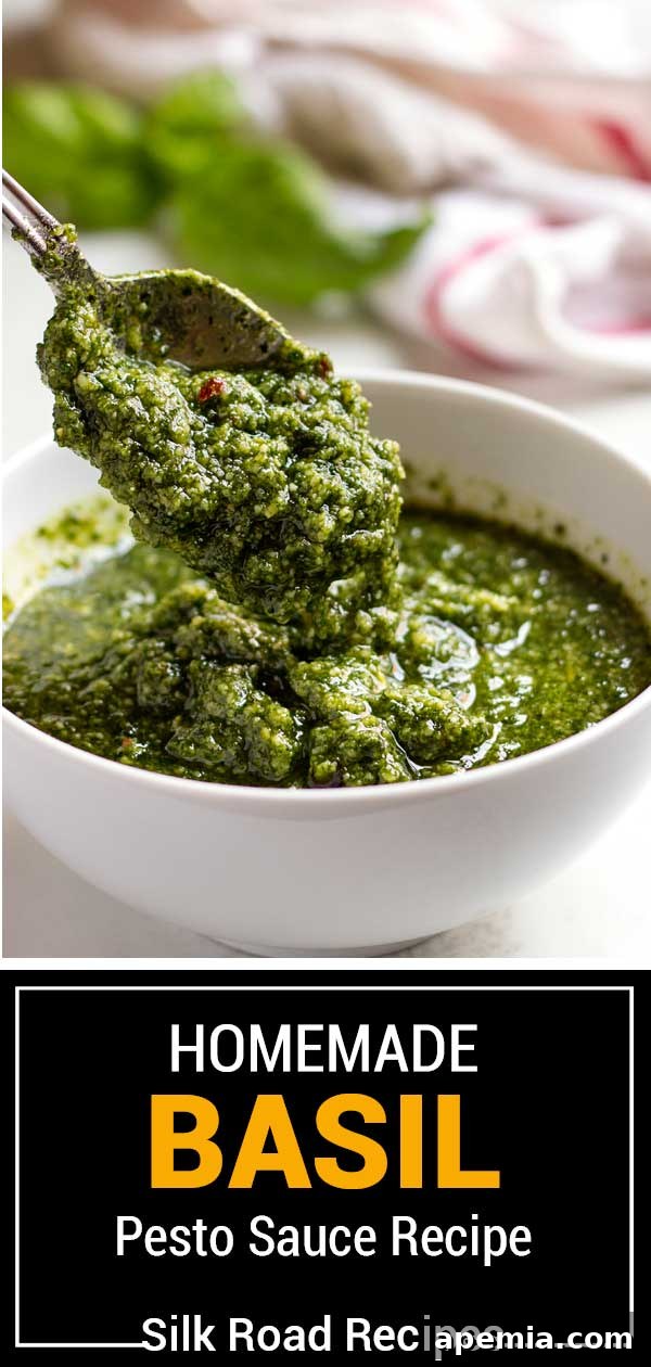 Beautifully presented bowl of vibrant basil pesto with fresh basil leaves and pine nuts scattered around