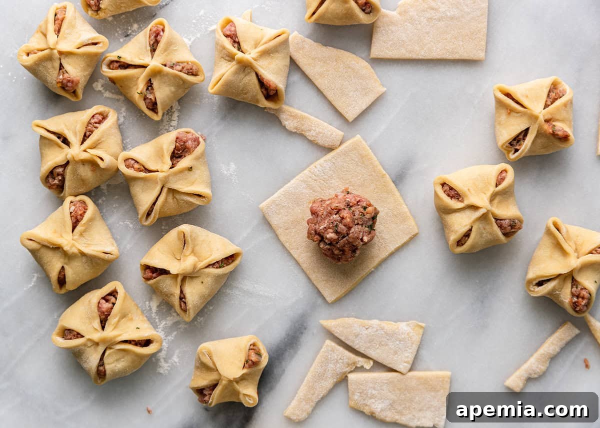 Overhead process shot: Hands expertly forming star-shaped Manti dumplings on a marble countertop, each filled with meat.