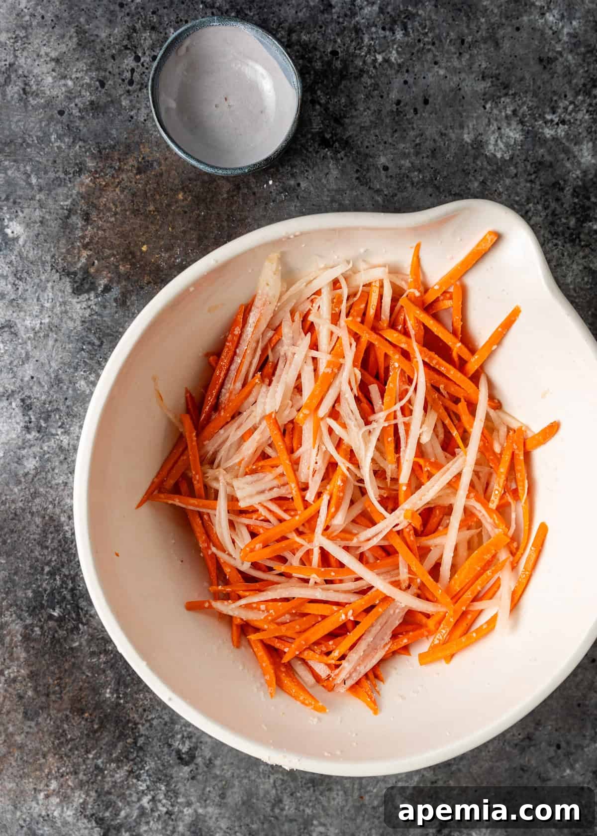 Crisp Vietnamese Pickled Daikon and Carrots 4 overhead process shot: salted carrots and daikon in a bowl