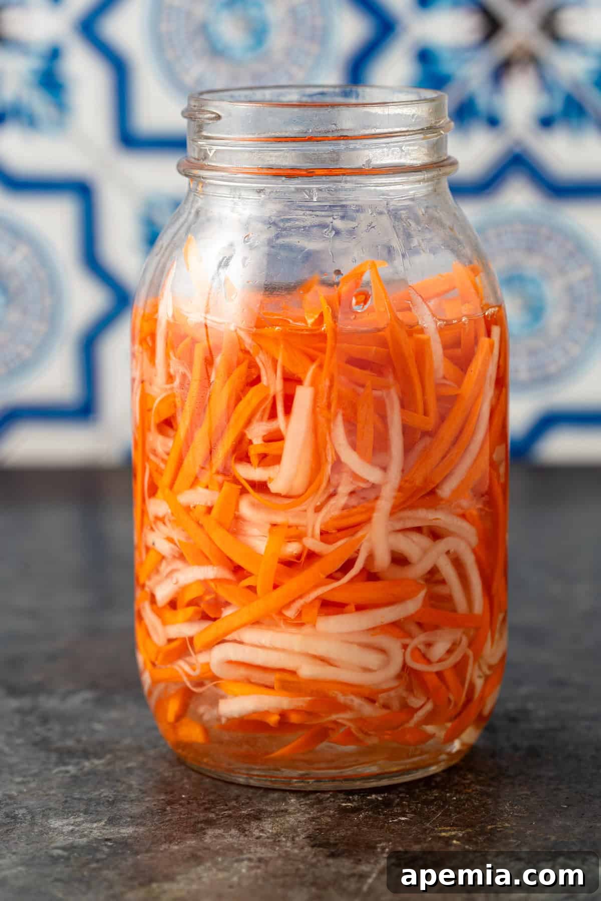 Crisp Vietnamese Pickled Daikon and Carrots 6 side view: Vietnamese pickled carrots and daikon in a glass jar