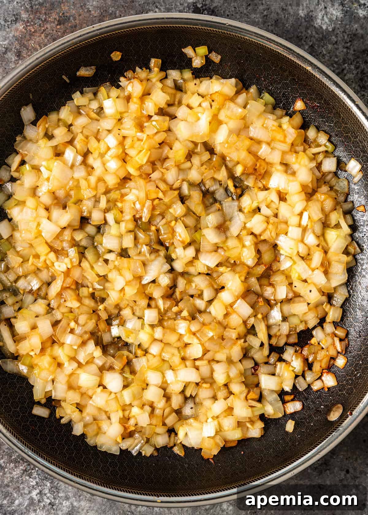 Creamy Hungarian Chicken Delight 6 overhead process shot: onion and garlic cooking in a skillet