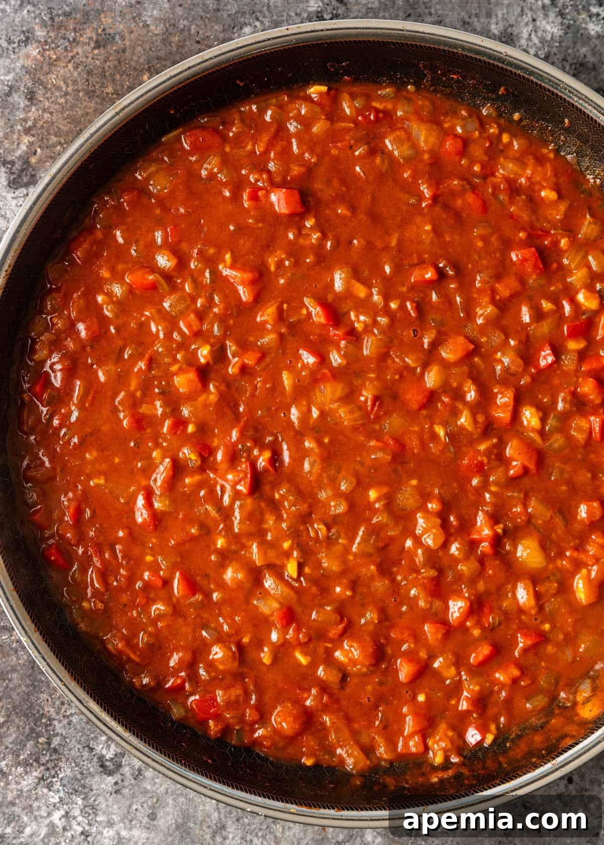 Creamy Hungarian Chicken Delight 8 overhead process shot: veggies cooking with tomato sauce in a skillet