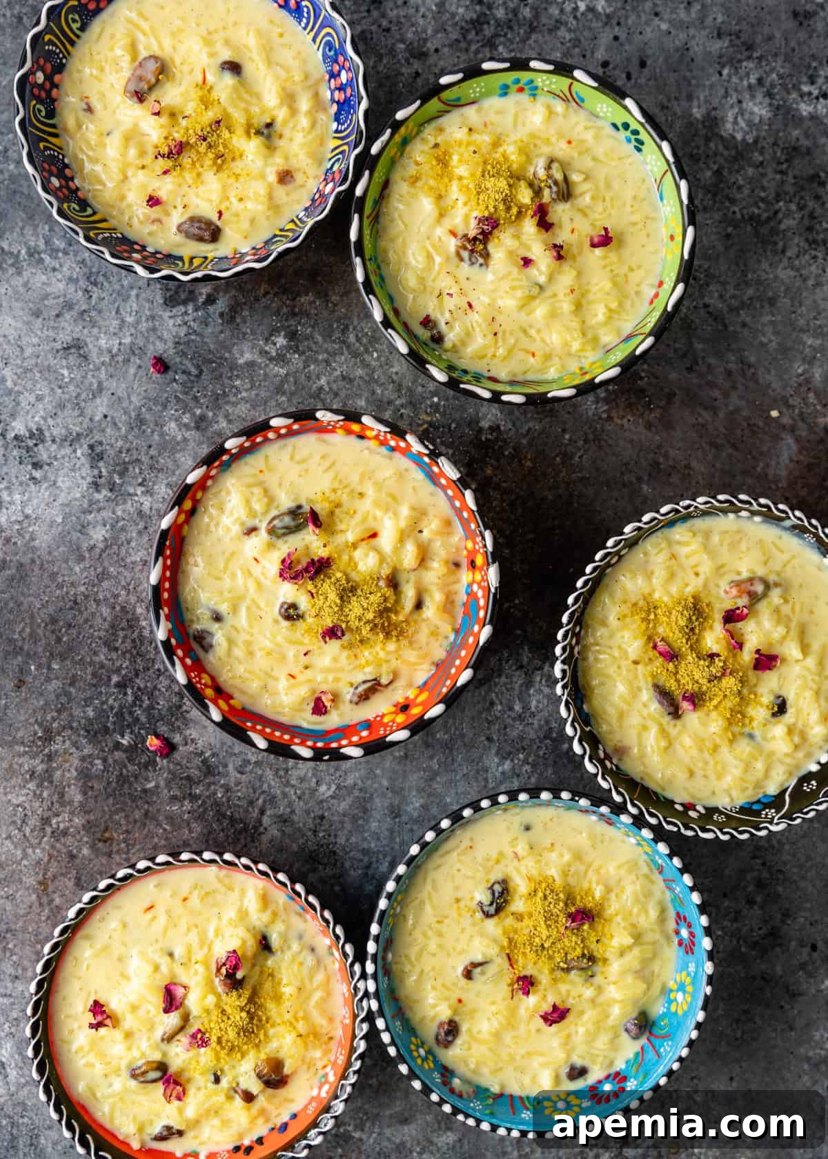 Indian Kheer Sweet Perfection 7 overhead: several bowls of Indian rice pudding with rose petals and pistachios on top