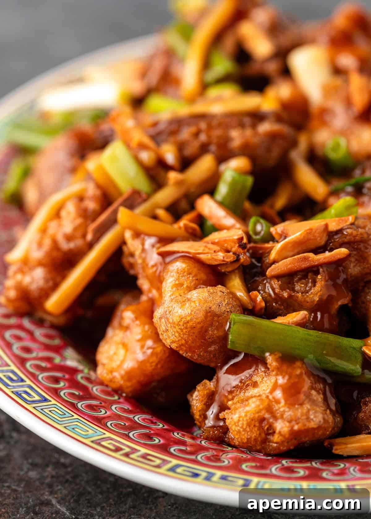 Overhead view of homemade almond chicken recipe served with carrots and bamboo shoots on a white plate