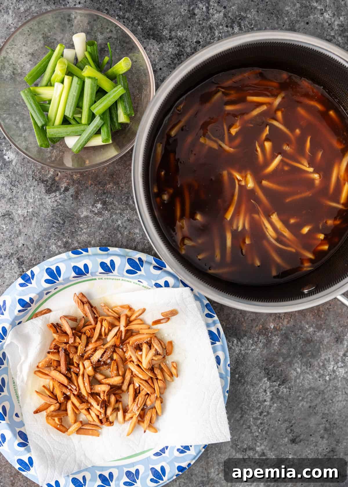 Overhead shot of ingredients being prepared and chopped for almond chicken recipe