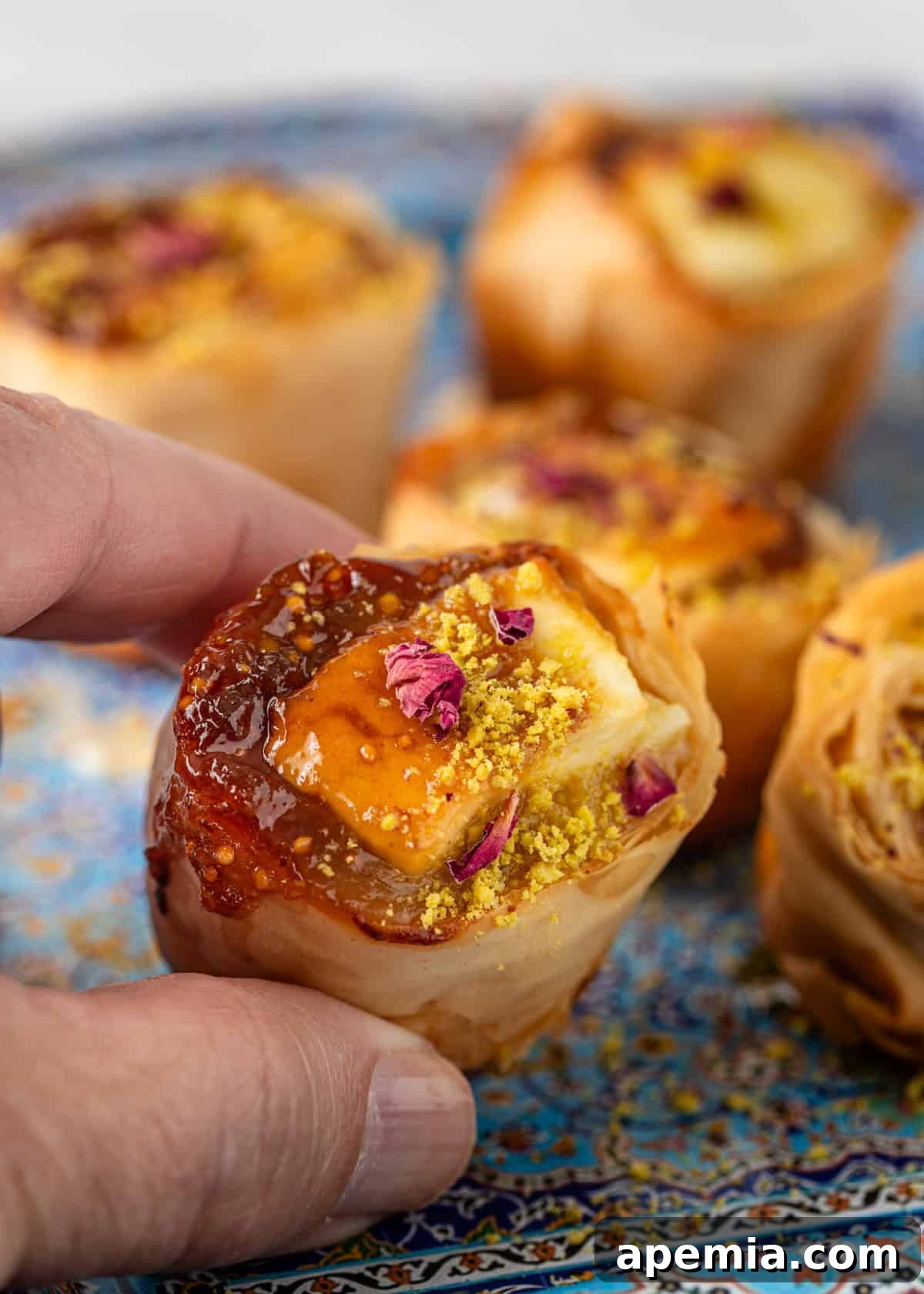 Closeup of freshly baked feta, glistening with honey and adorned with a sprinkle of crushed pistachios.