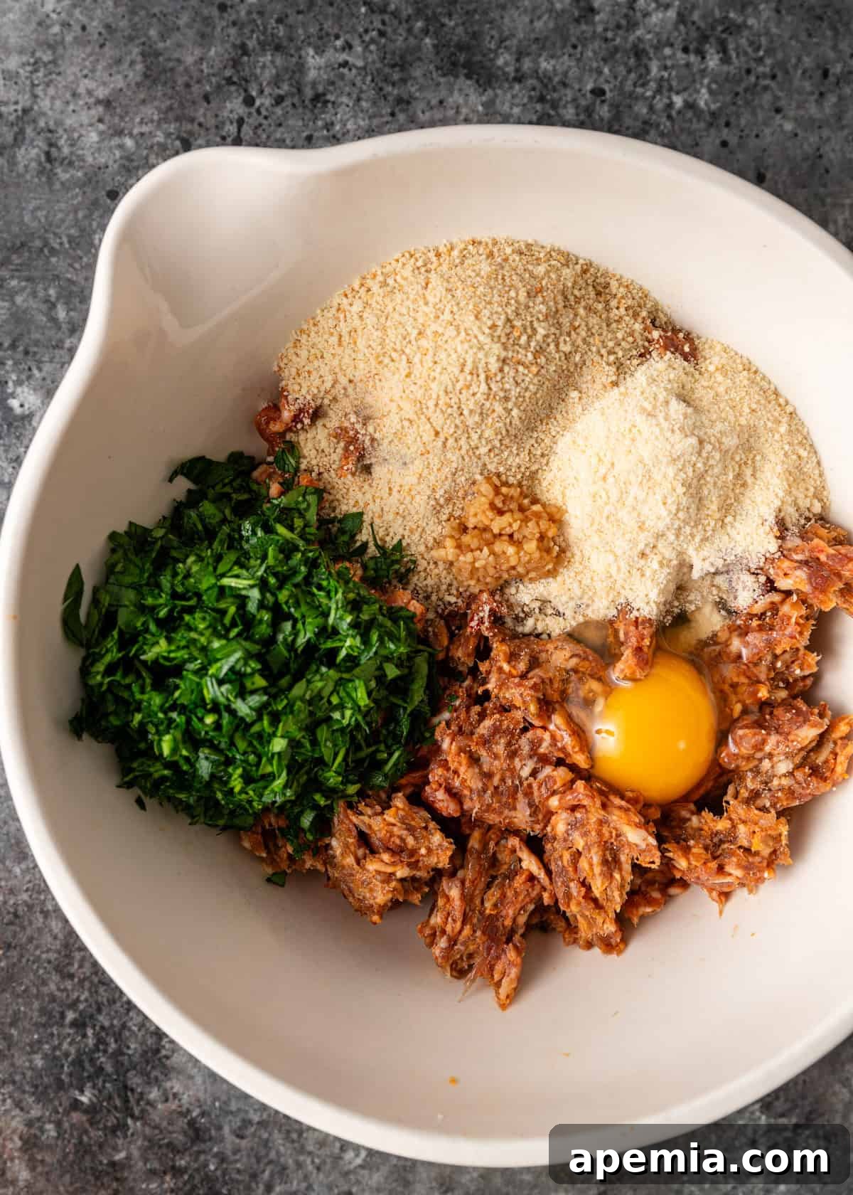 overhead: meatballs ingredients for Italian wedding soup in a bowl before mixing