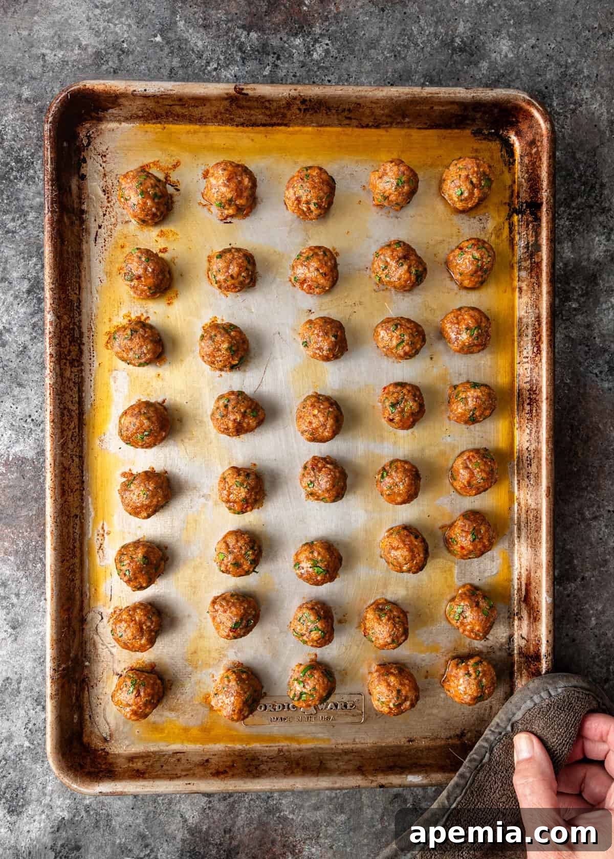 overhead process shot: meatballs on a baking sheet after baking