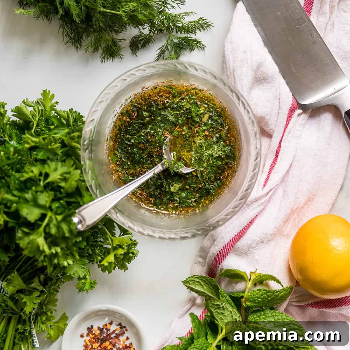 Overhead view of a small glass bowl filled with vibrant Mediterranean chicken marinade, ready for use.