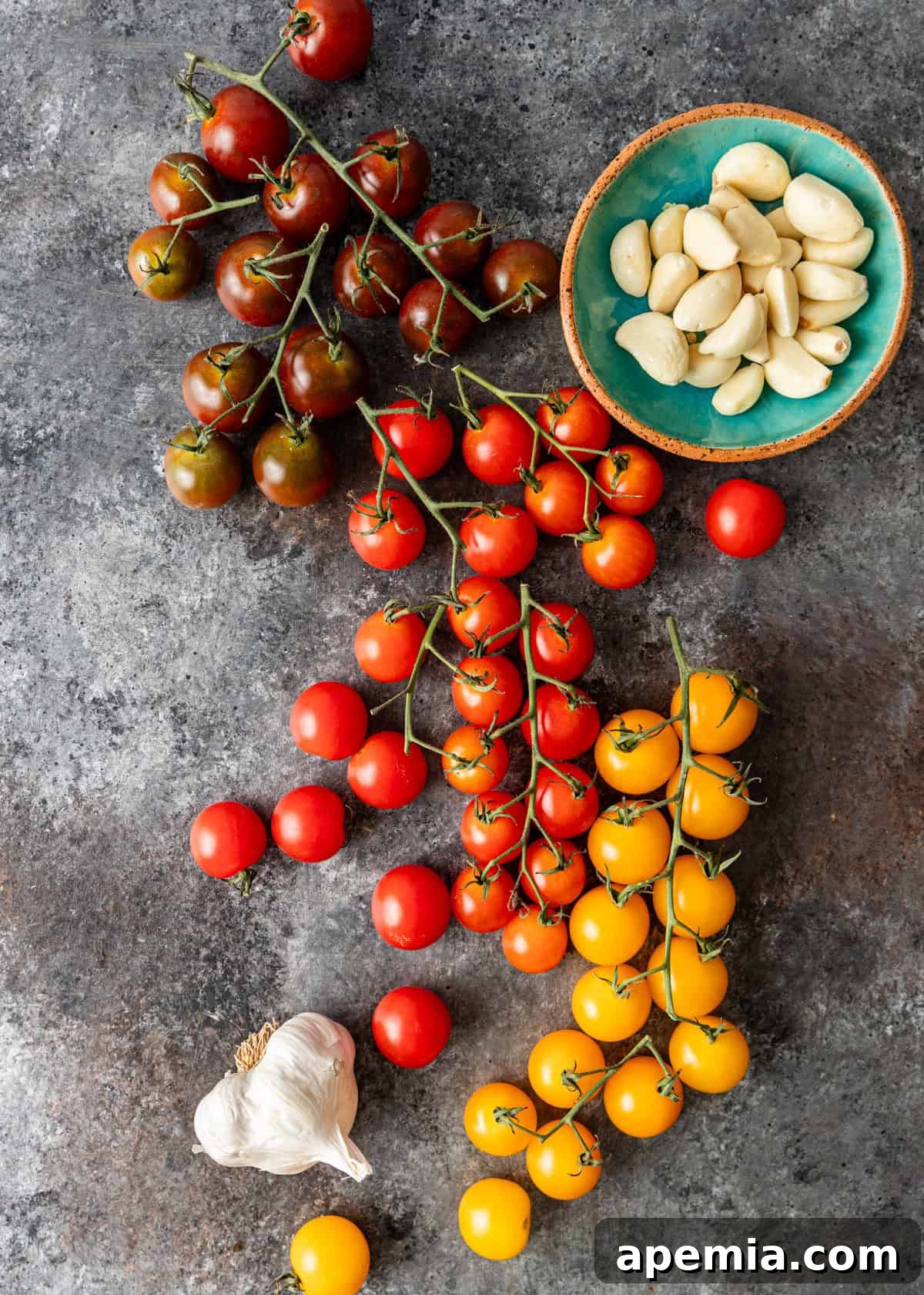 Overhead shot: all ingredients needed to make stovetop tomato confit displayed on a counter.