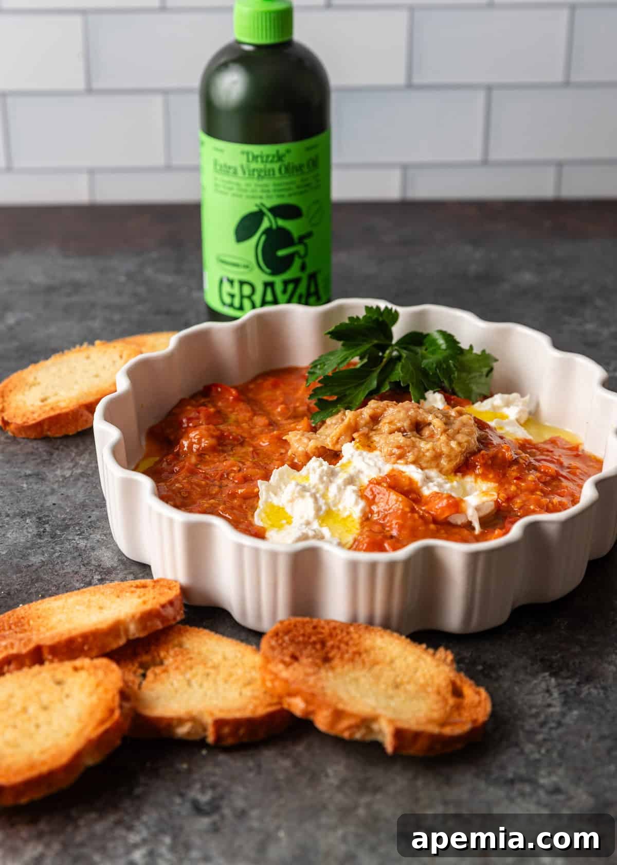Tomato confit recipe served as a dip with toasted bread. Close up of a vibrant dip.