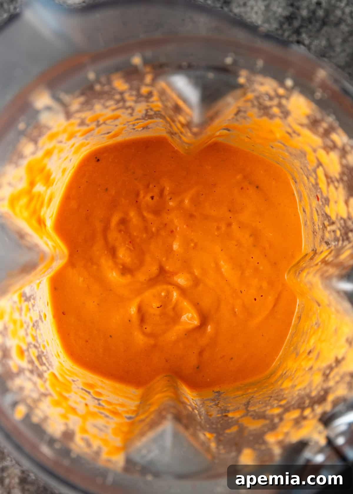 Overhead process shot: tomato confit sauce in a blender after blending, showcasing its smooth and vibrant texture