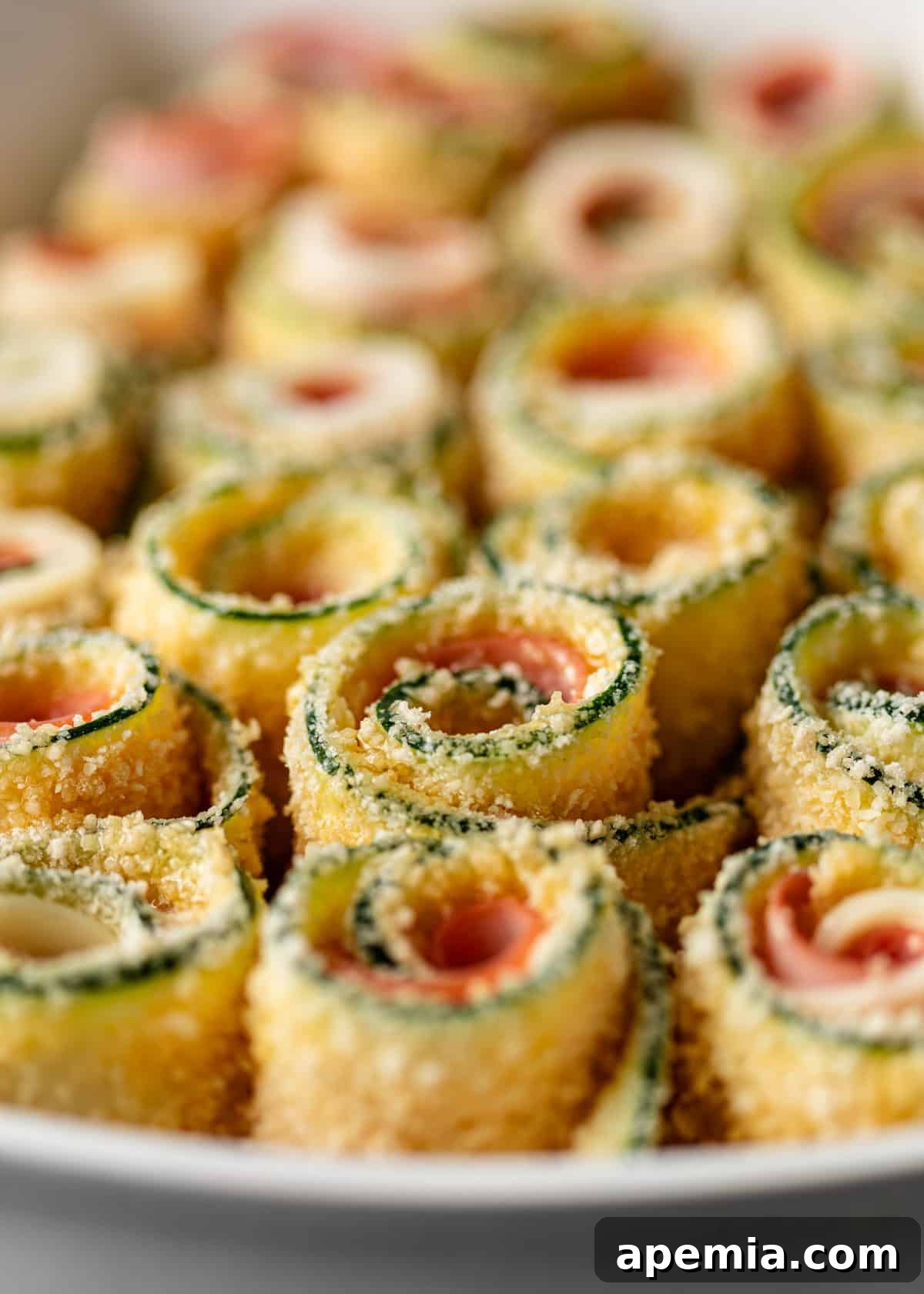 Closeup of Zucchini Involtini arranged neatly in a baking dish, glistening with olive oil, before being placed in the oven.