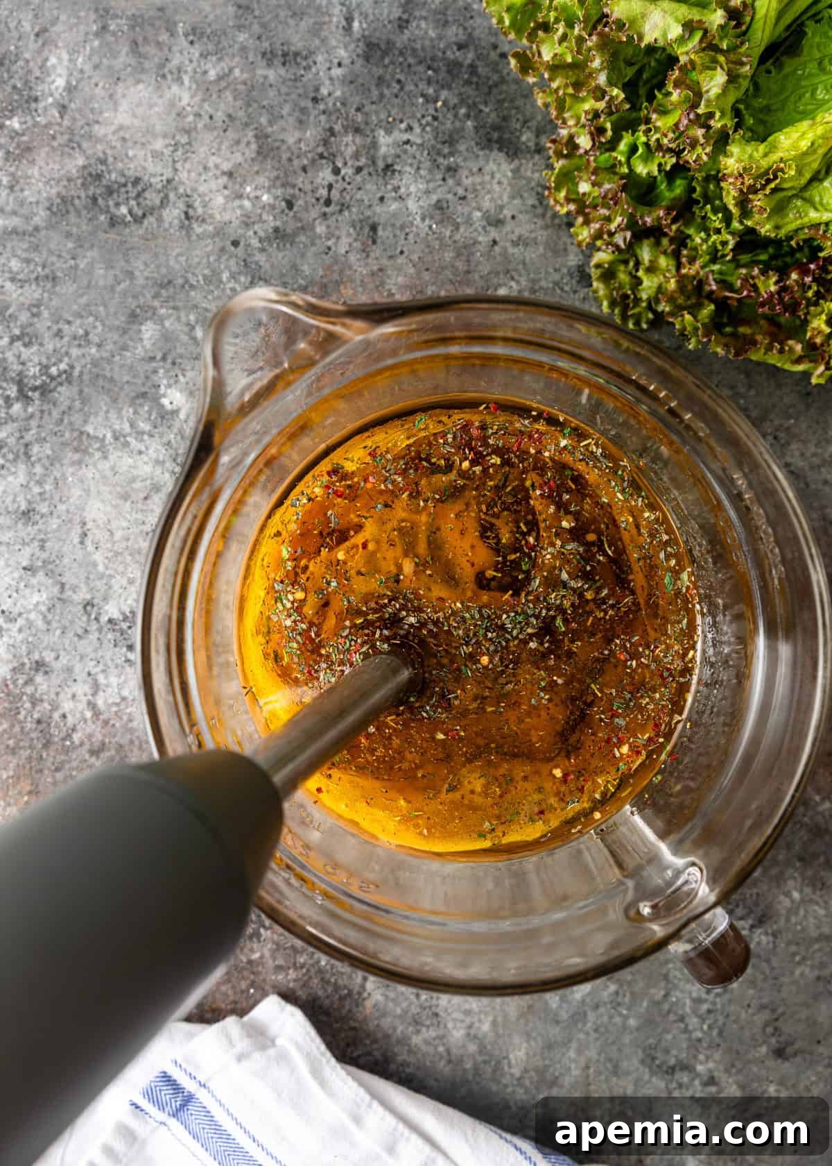Homemade Italian Dressings Two Ways 5 Overhead view showing the blending process of the Italian salad dressing in a glass measuring cup using an immersion blender.