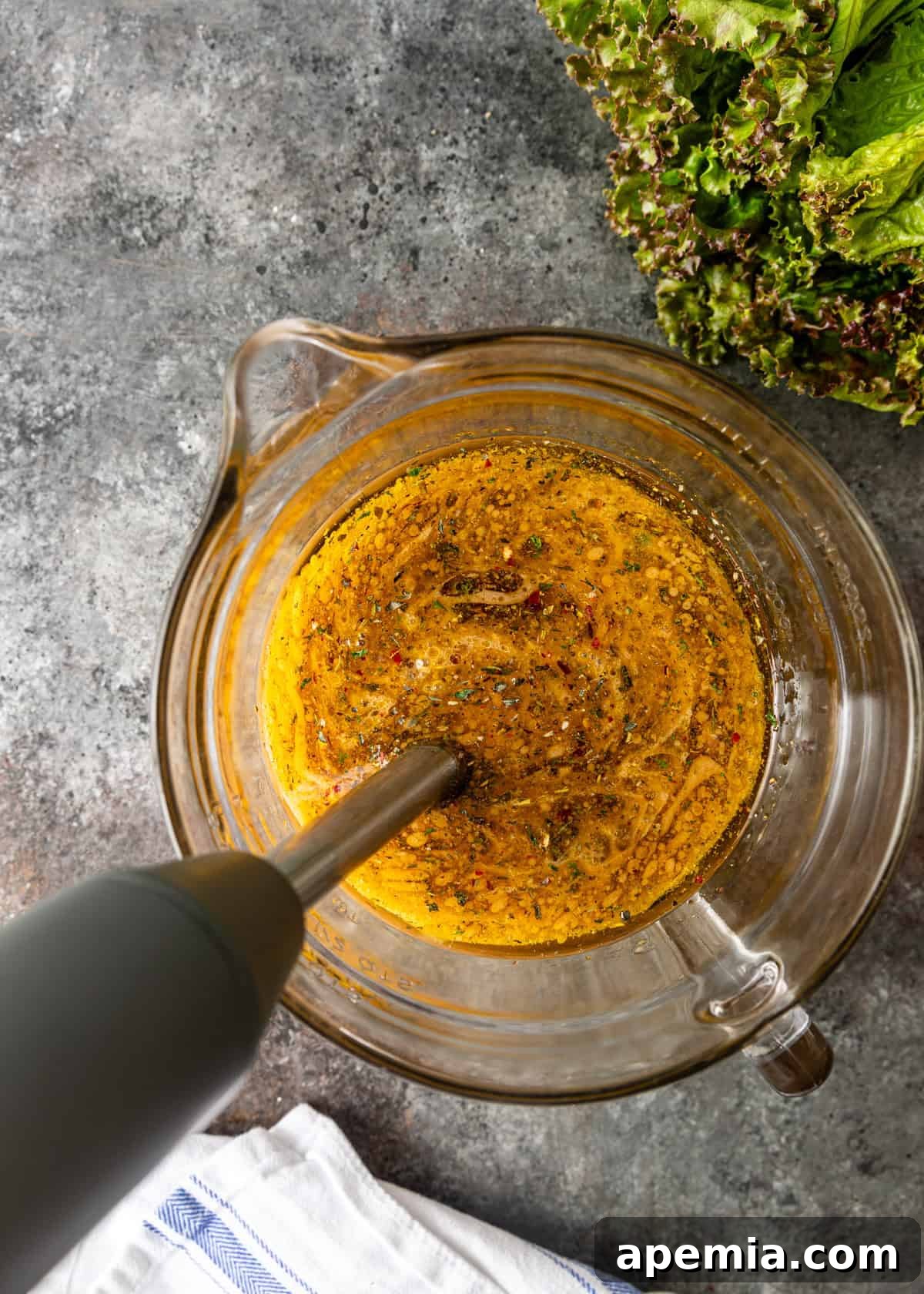 Homemade Italian Dressings Two Ways 6 Another overhead shot capturing the immersion blender actively mixing homemade Italian dressing in a glass container.