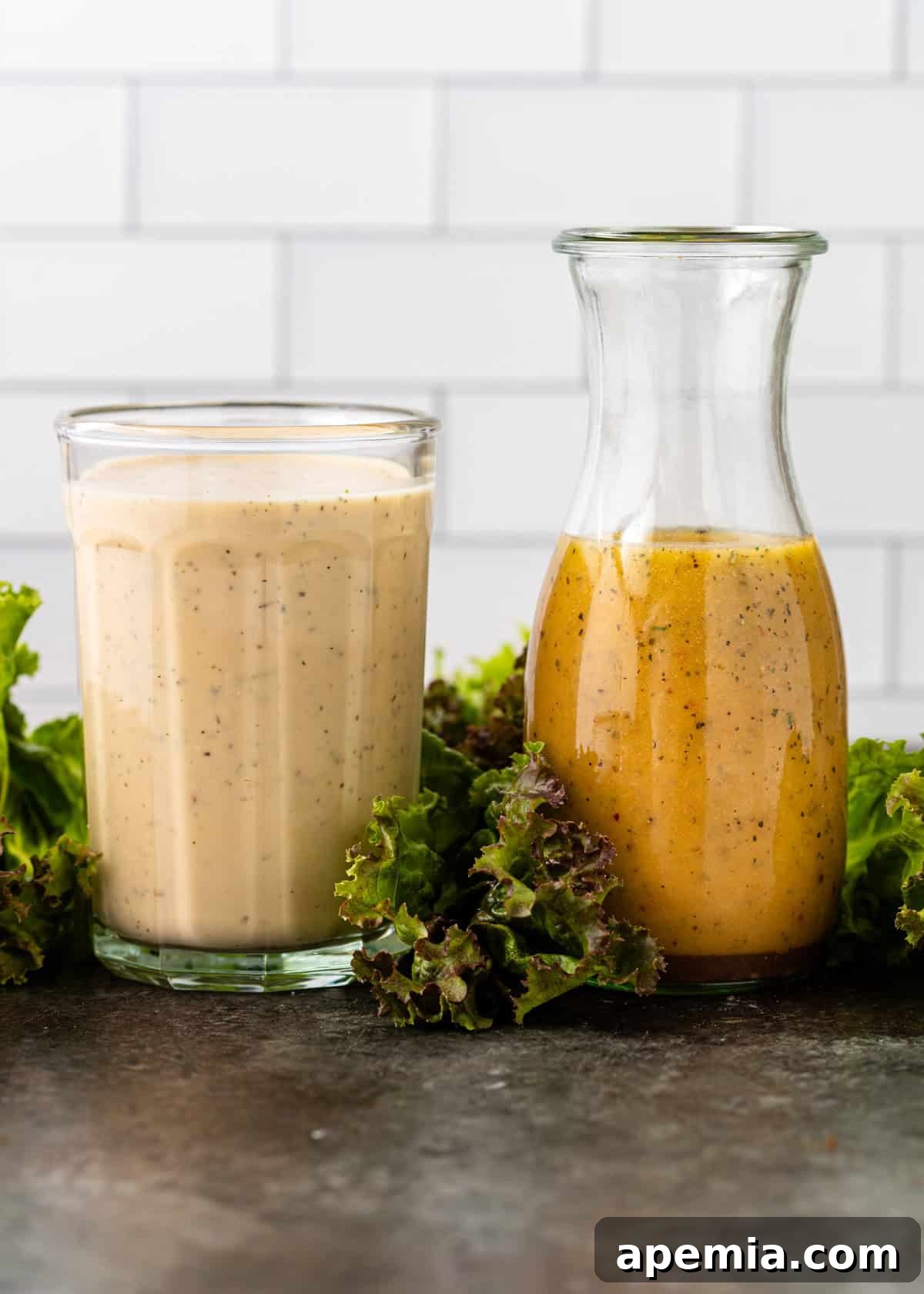 Homemade Italian Dressings Two Ways 9 Side view of two glass jars, one containing a classic Italian vinaigrette and the other a creamy Italian dressing, side-by-side.