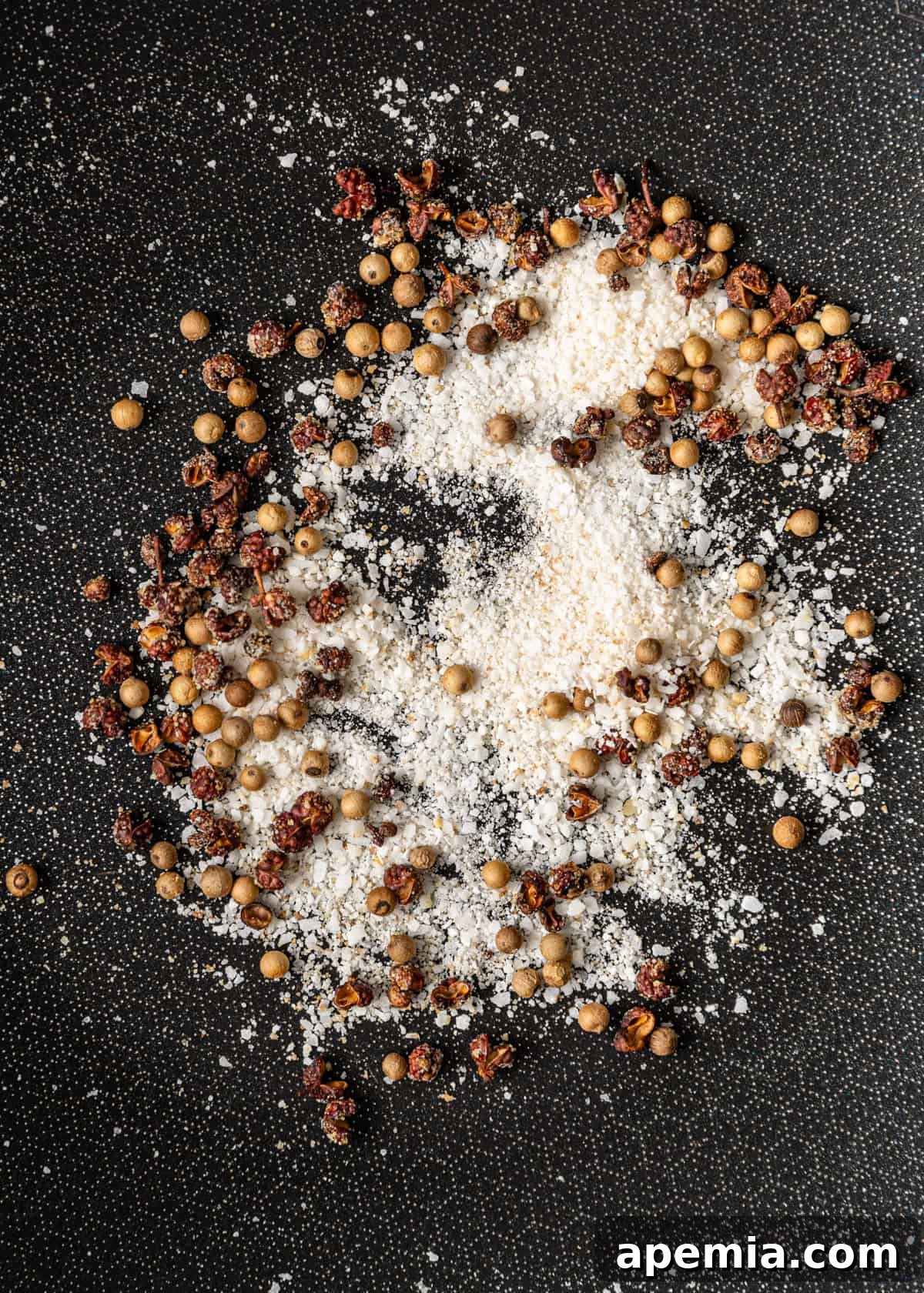overhead process shot: toasting salt and peppercorns in a hot wok