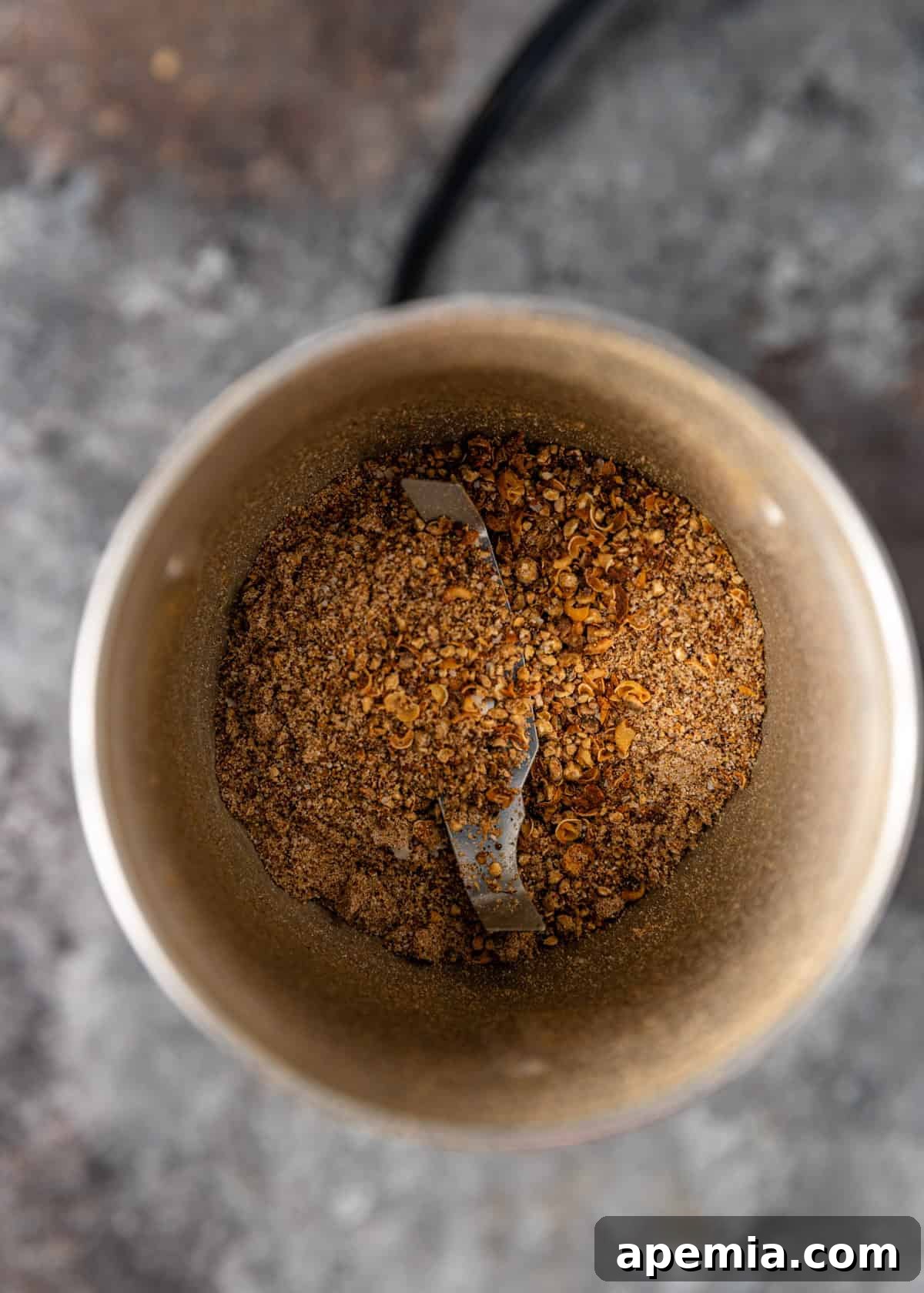 overhead process shot: grinding the toasted spices in a spice blender