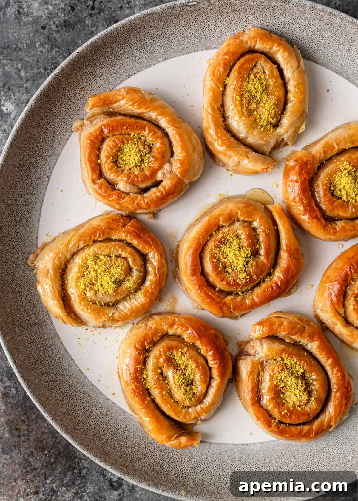 Mhencha: Moroccan Coiled Almond Delight 13 Overhead shot of beautifully arranged Mhencha pastries on a serving platter, generously topped with crushed pistachios.
