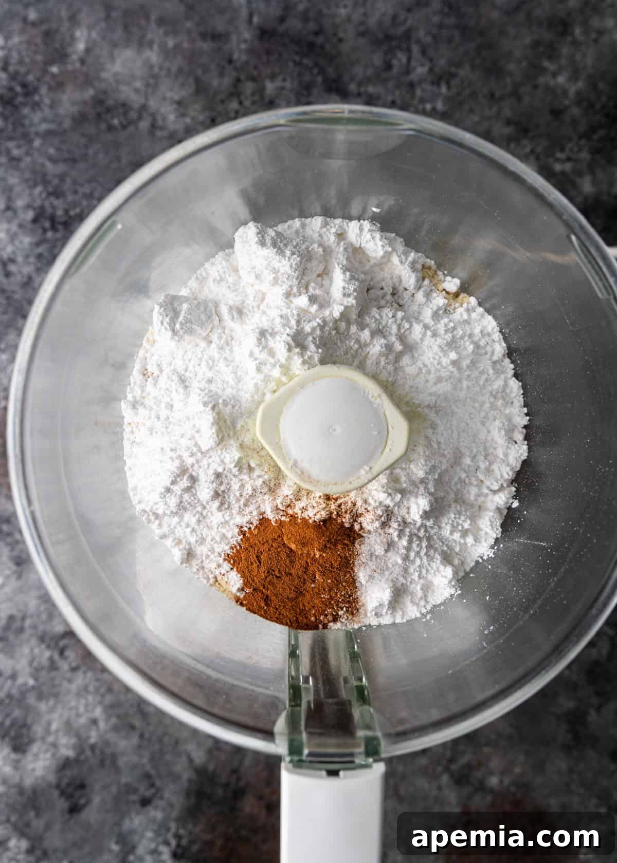 Mhencha: Moroccan Coiled Almond Delight 5 Overhead process shot: almond flour, sugar, cinnamon, and salt in a food processor bowl before blending.