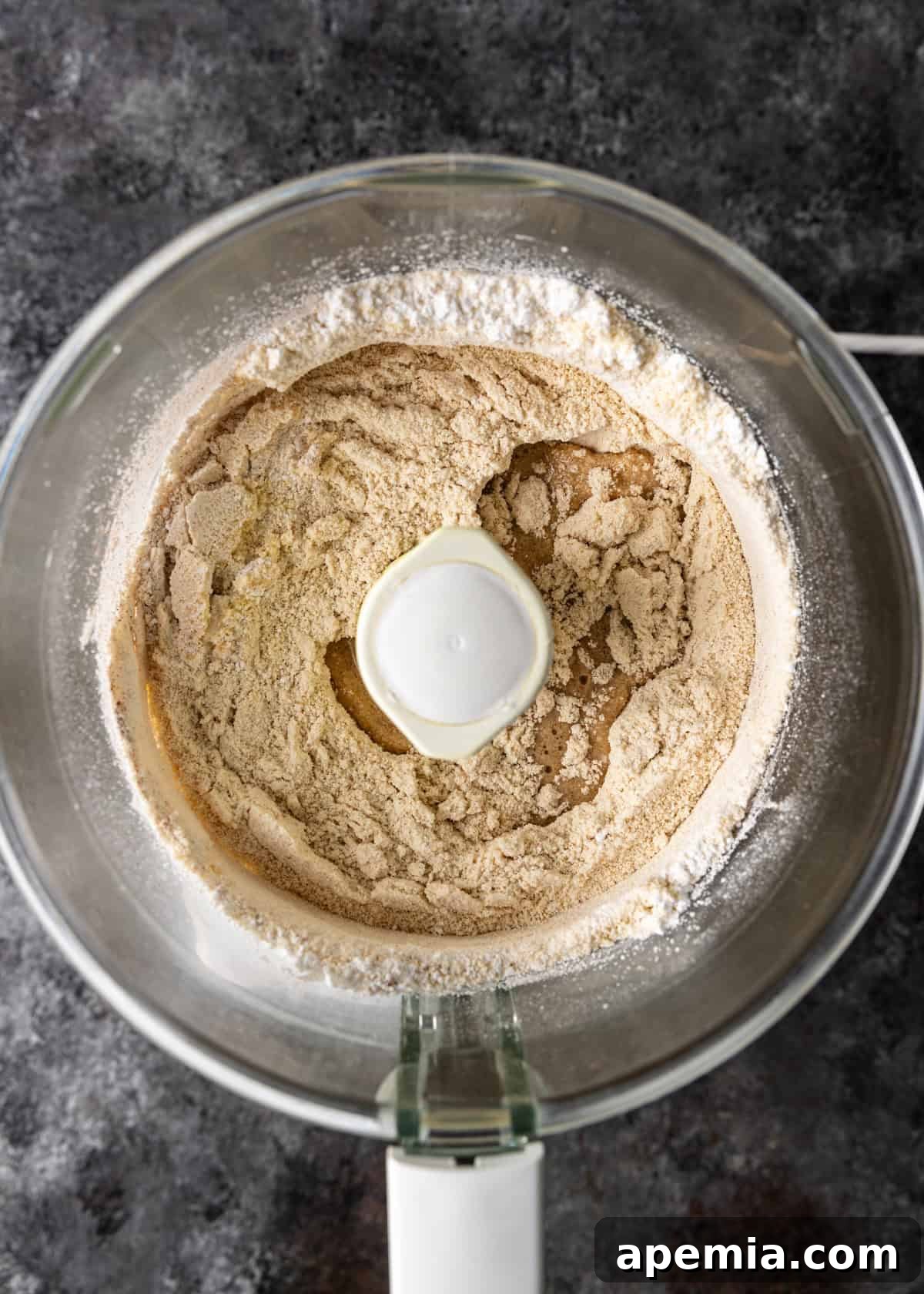 Mhencha: Moroccan Coiled Almond Delight 6 Overhead process shot: almond flour, sugar, cinnamon, and salt being blended in a food processor.