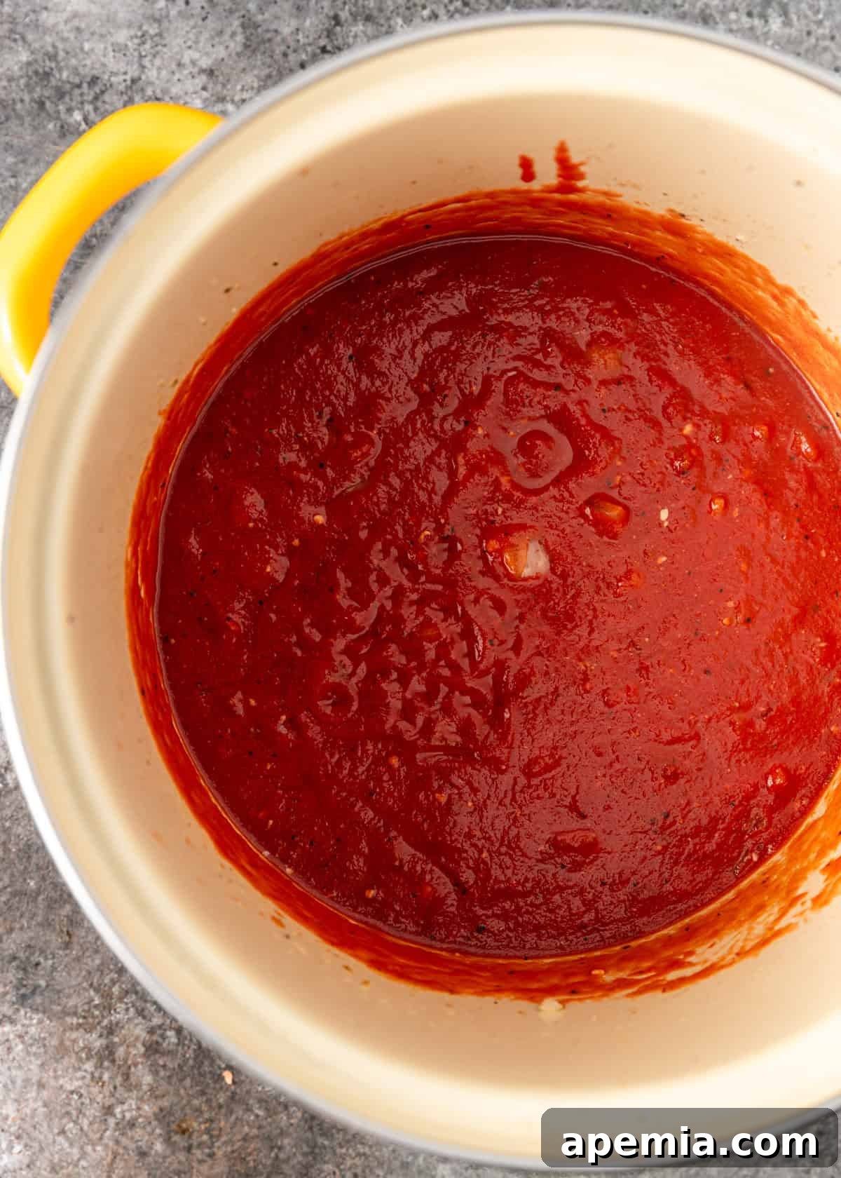 Overhead process shot: showing the rich, reduced tomato paste after cooking, deepening its flavor.