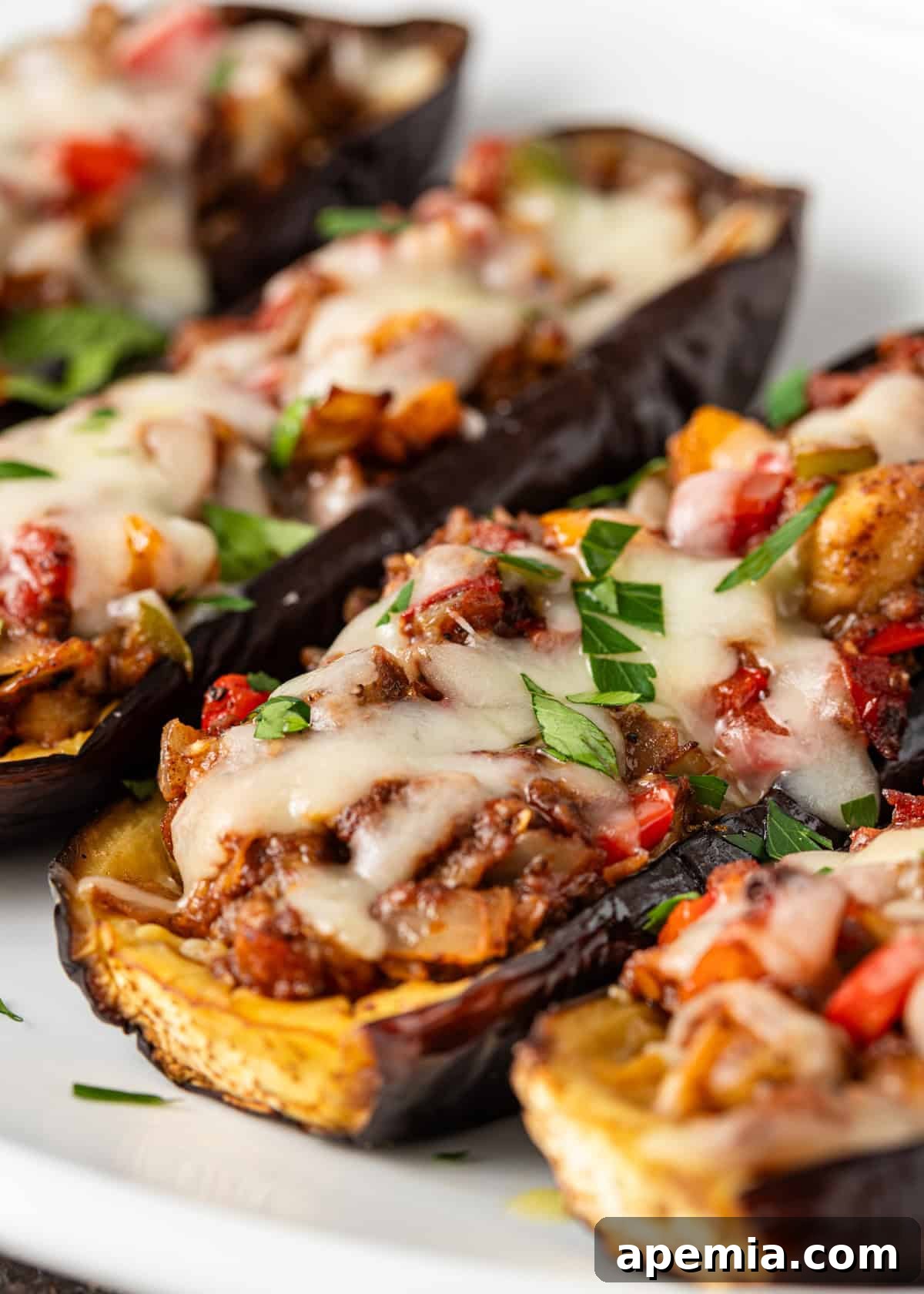 closeup: my stuffed eggplant recipe topped with melted cheese and chopped fresh herbs