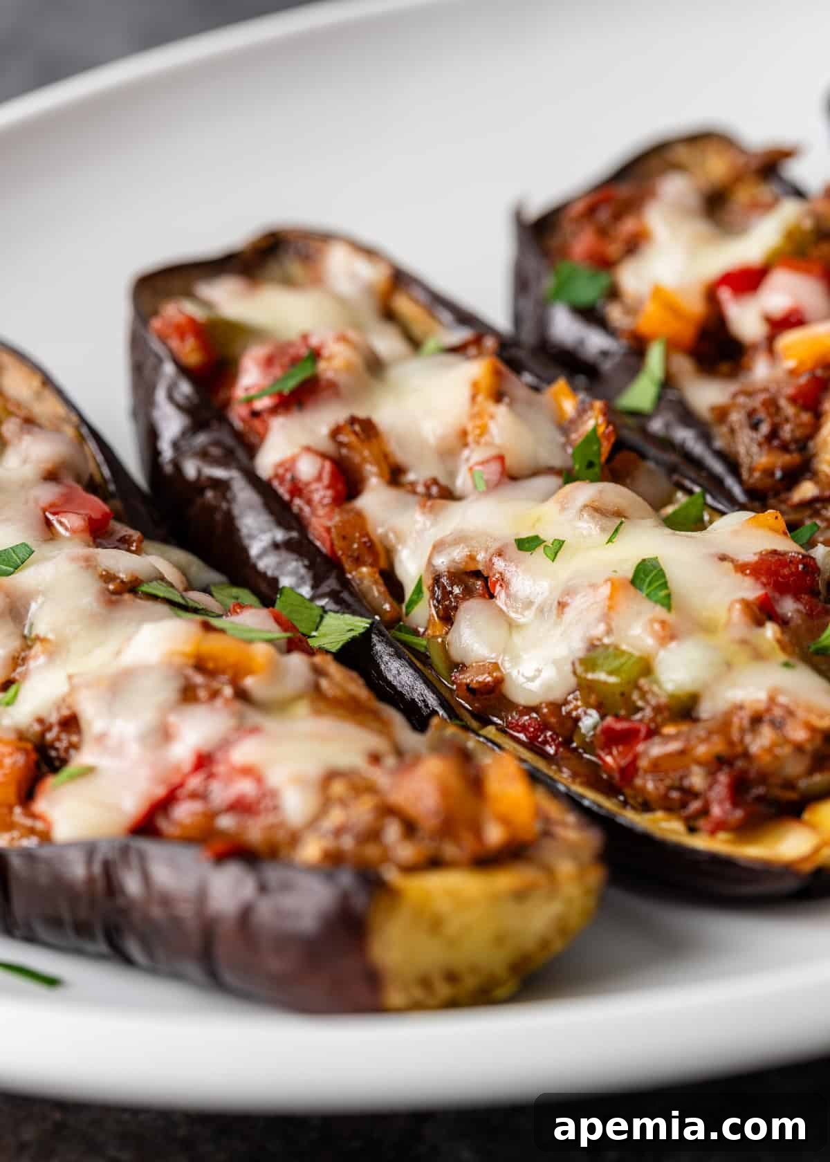 closeup: my stuffed eggplant recipe topped with melted cheese and chopped fresh herbs