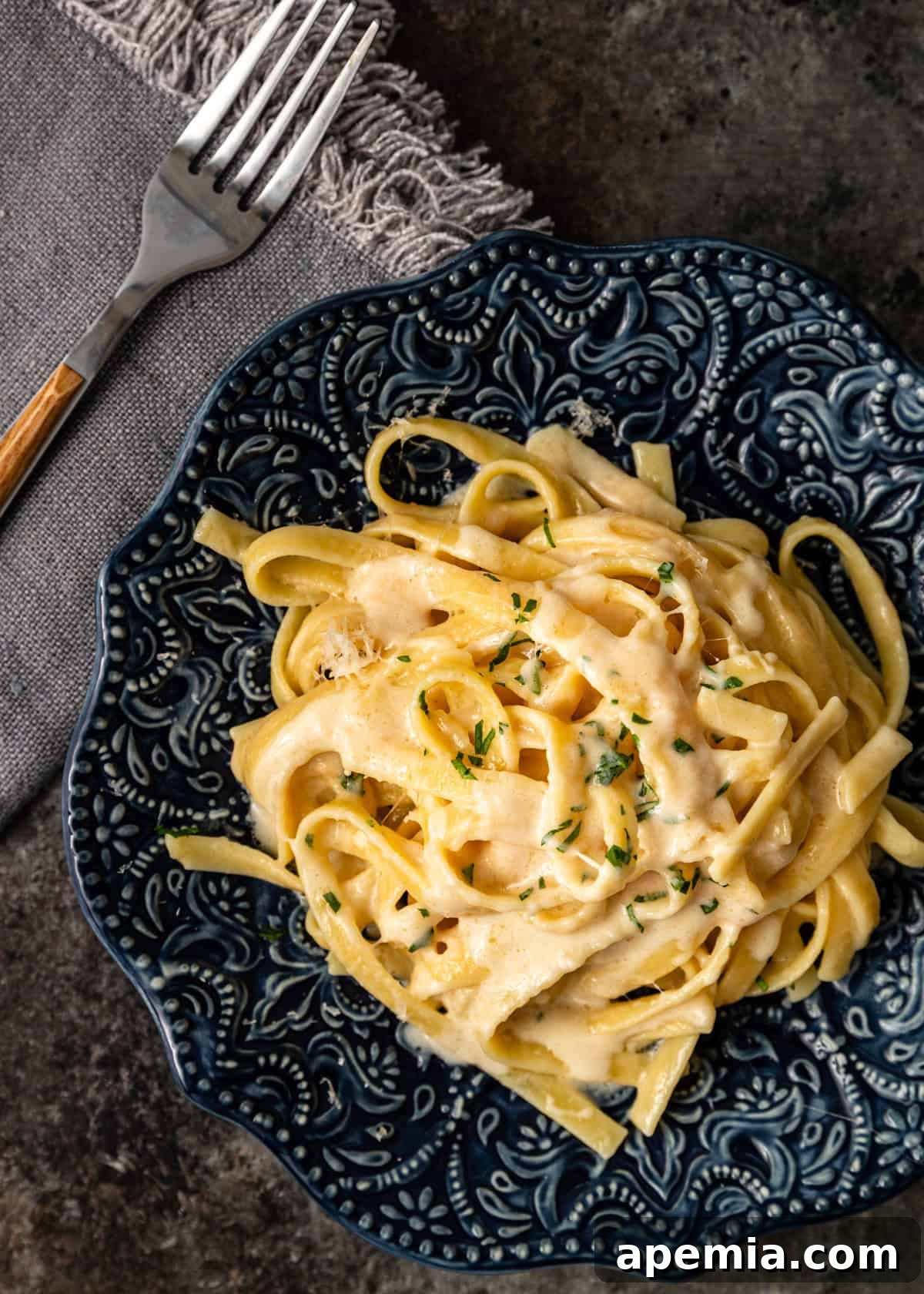 overhead: a serving of fettuccine al burro on a blue ceramic plate