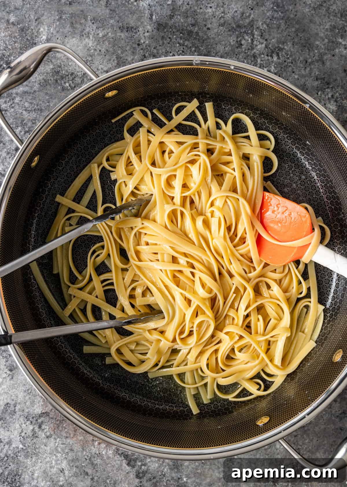 overhead process shot: tossing the cooked pasta in the melted butter