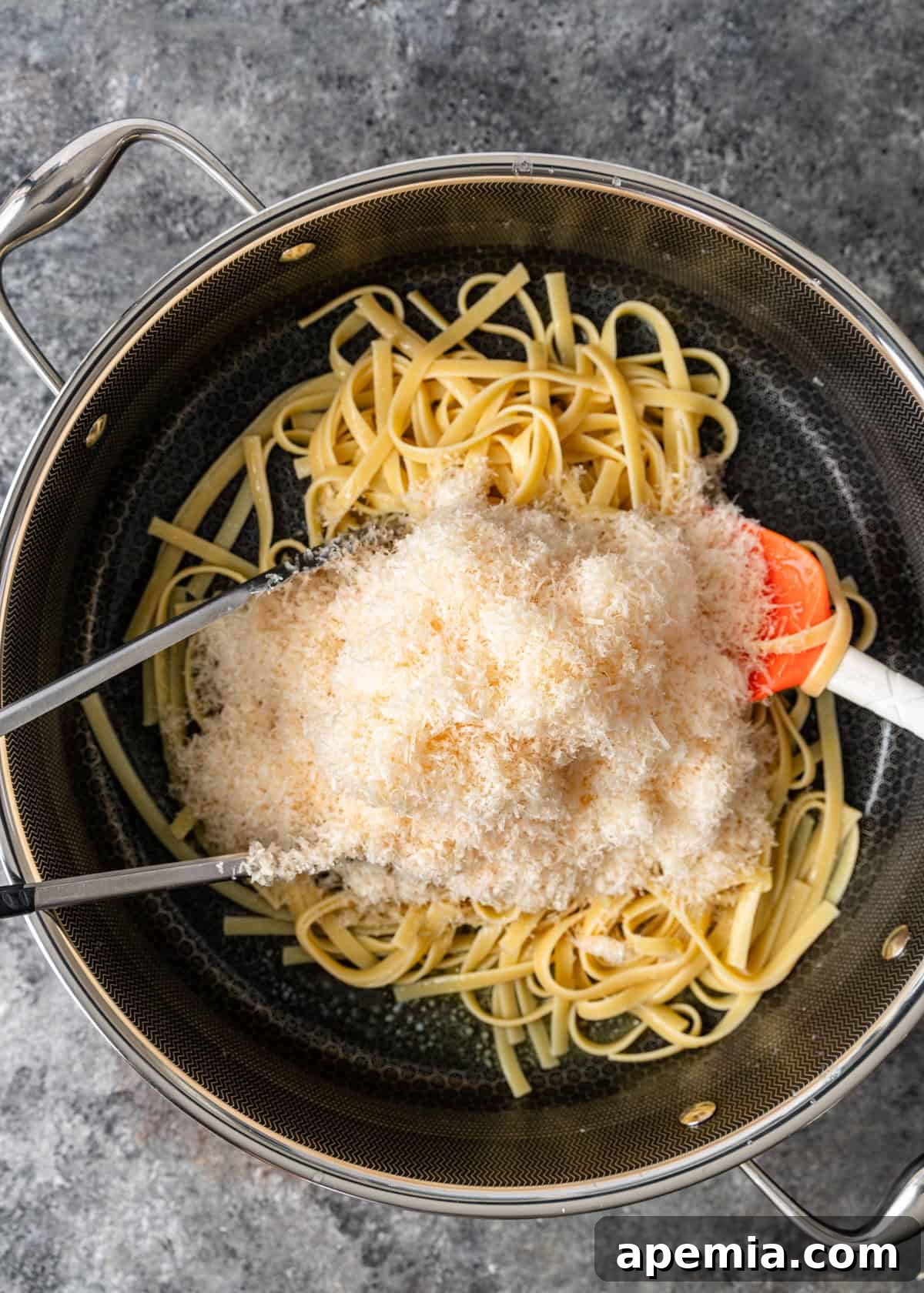 overhead process shot: adding the grated parmesan to the same skillet